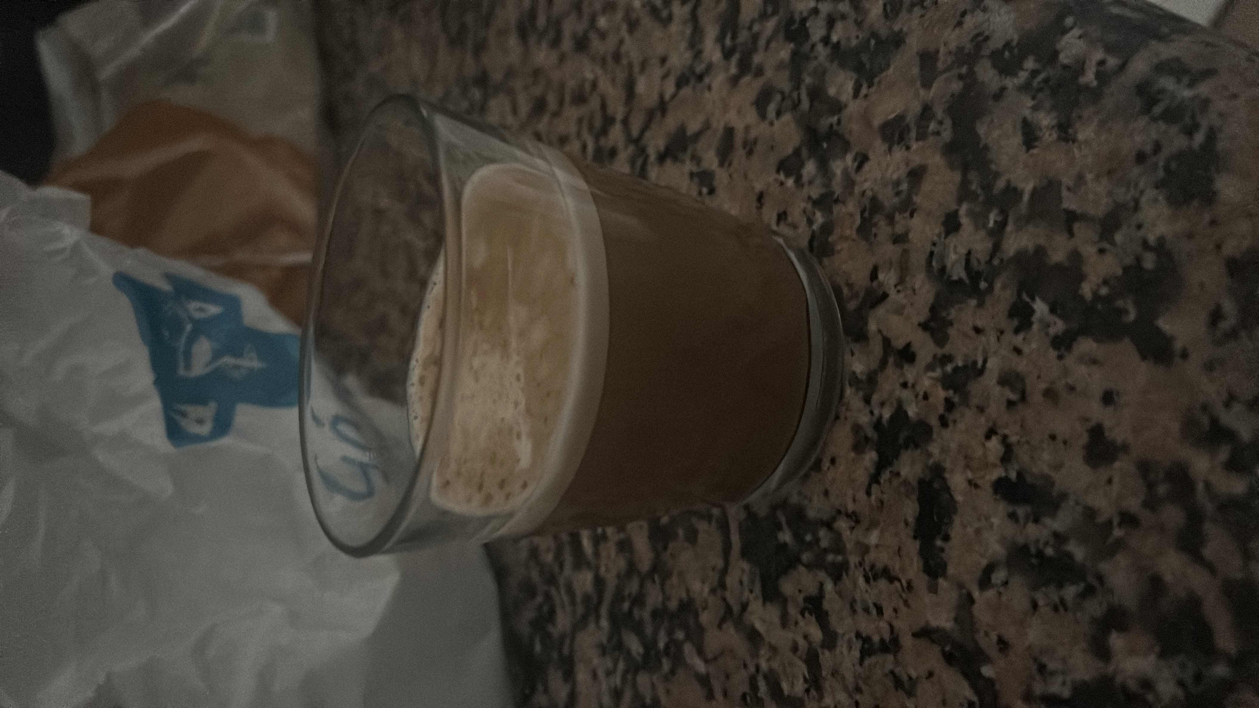 A small glass of coffee with milk, providing a moderate amount of calories and a balanced nutritional profile.