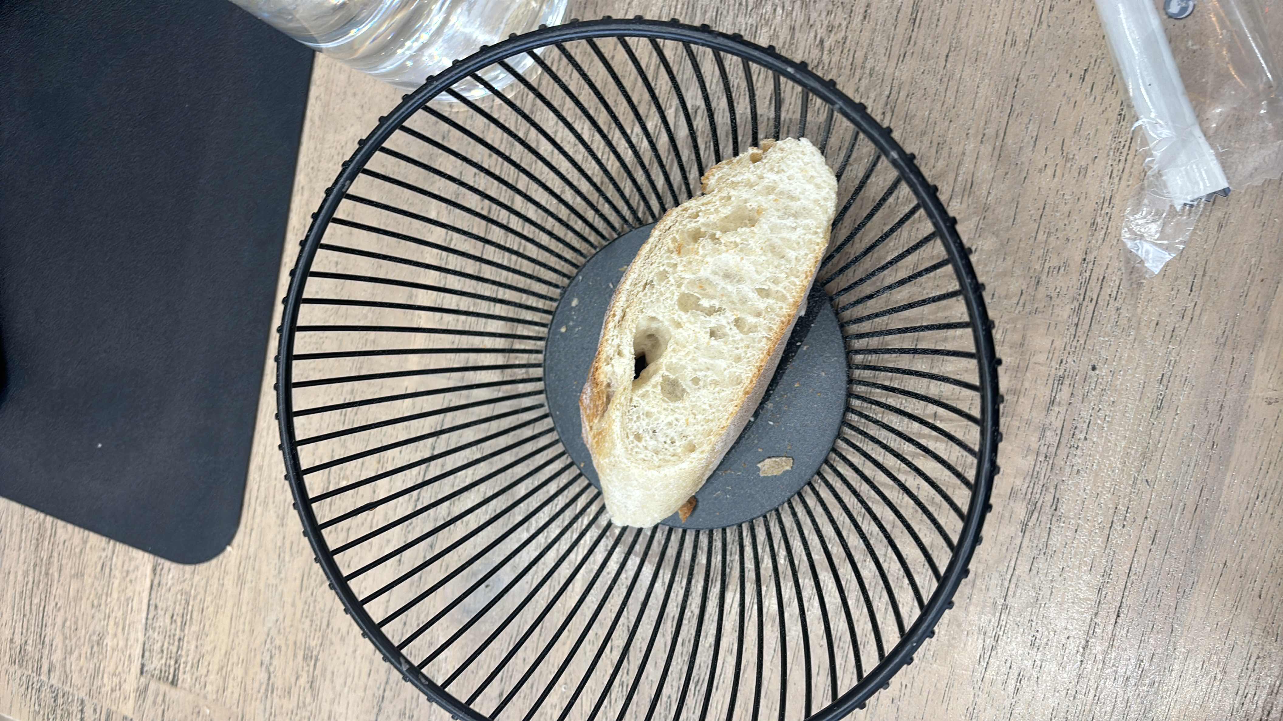 A single slice of bread in a basket, providing basic nutritional value with moderate carbs and low protein and fat content.