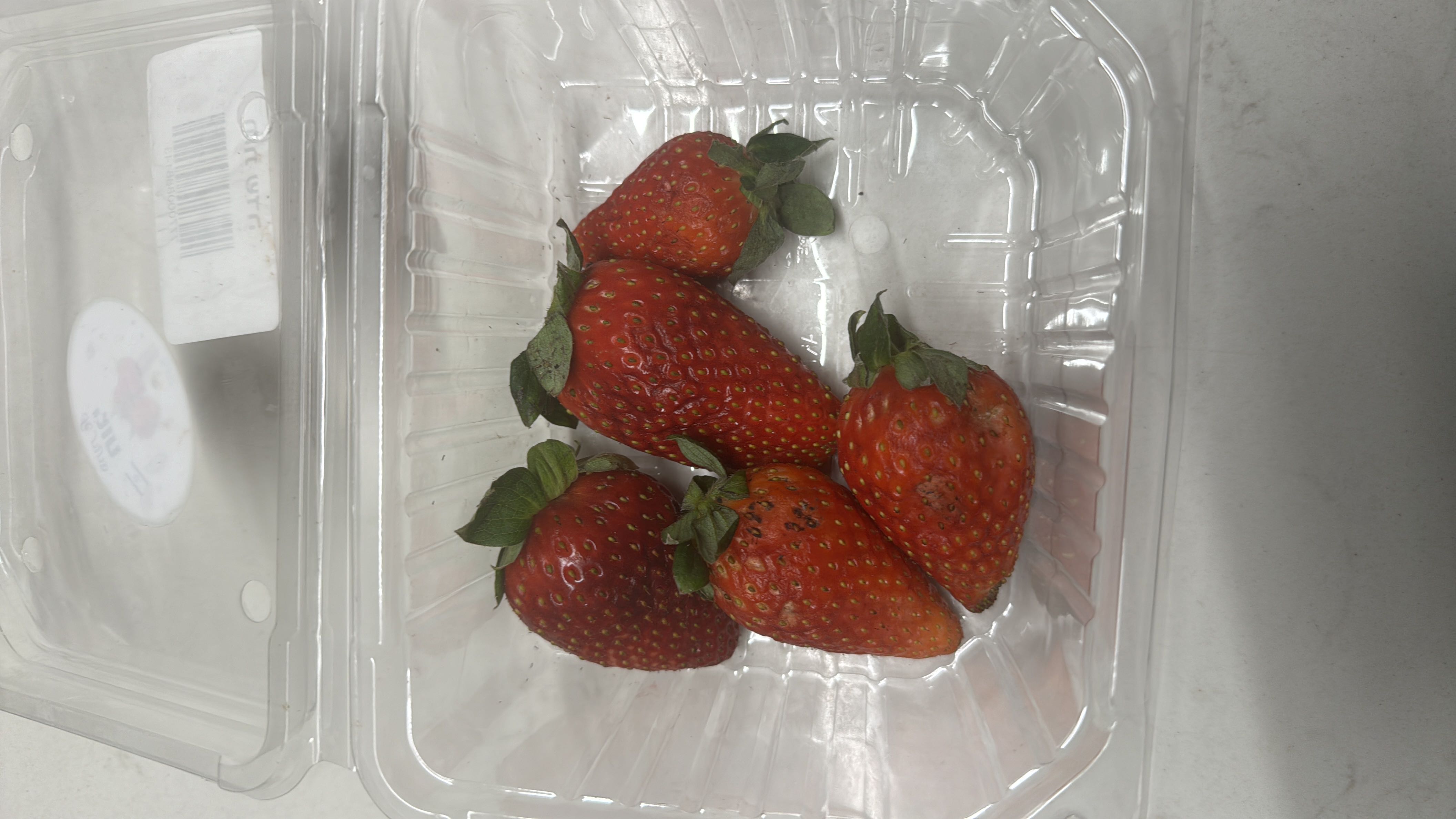 The image shows a container of fresh strawberries, which are low in calories and rich in vitamins and antioxidants.