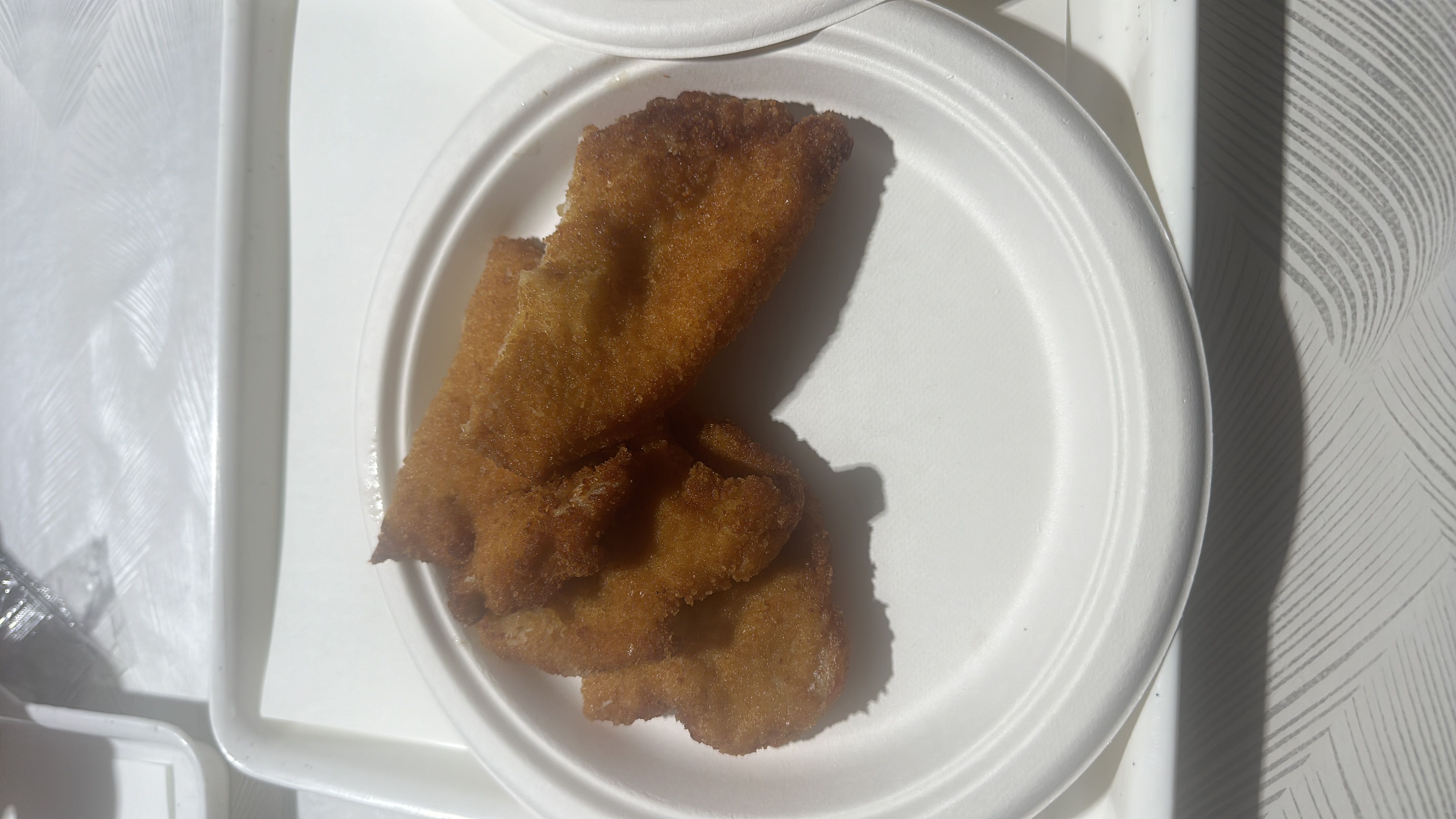 A plate of breaded and fried fish fillets, providing a moderate balance of protein, carbs, and fats.