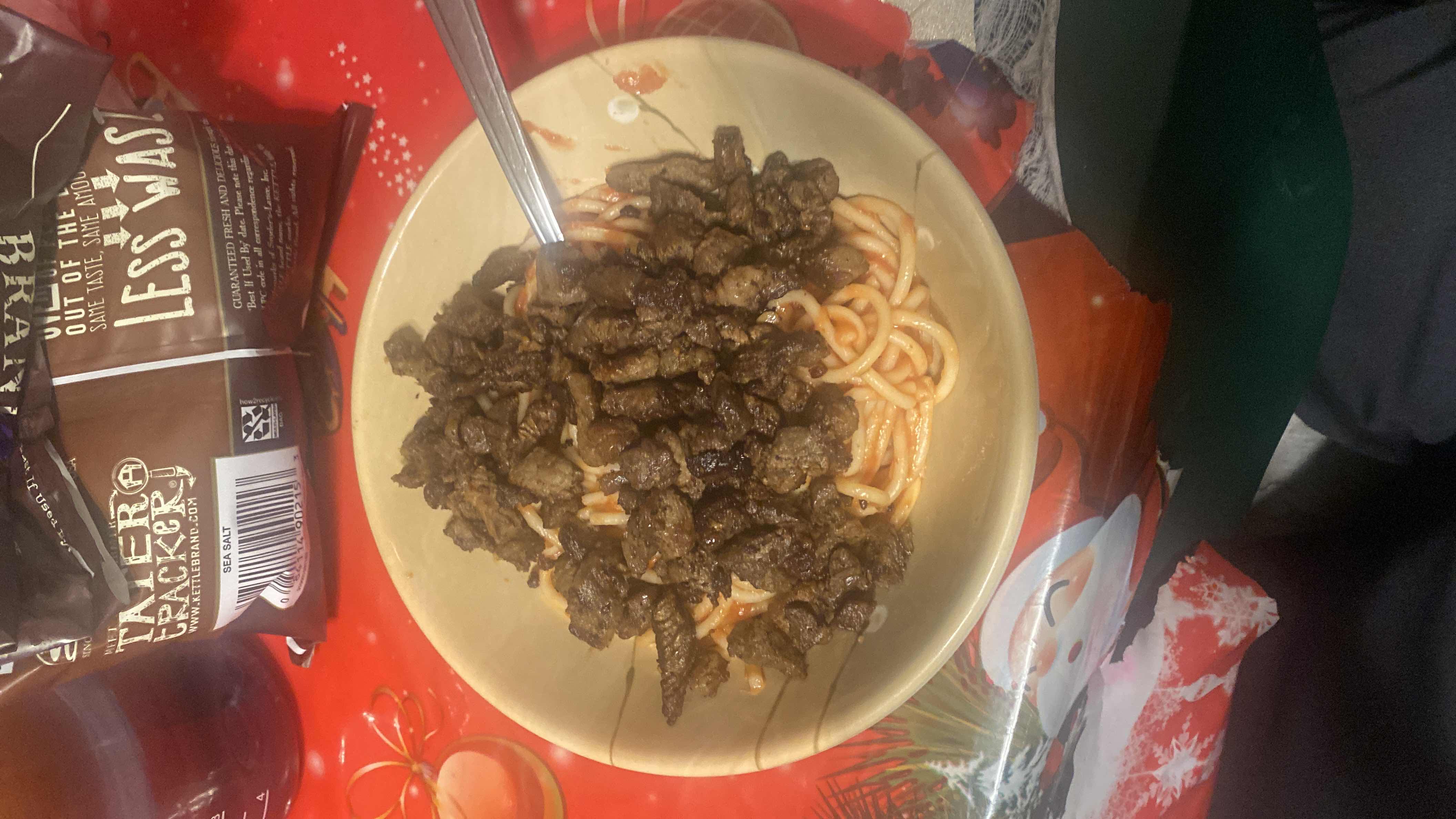 A dish consisting of spaghetti topped with cooked beef and tomato sauce, served in a bowl.