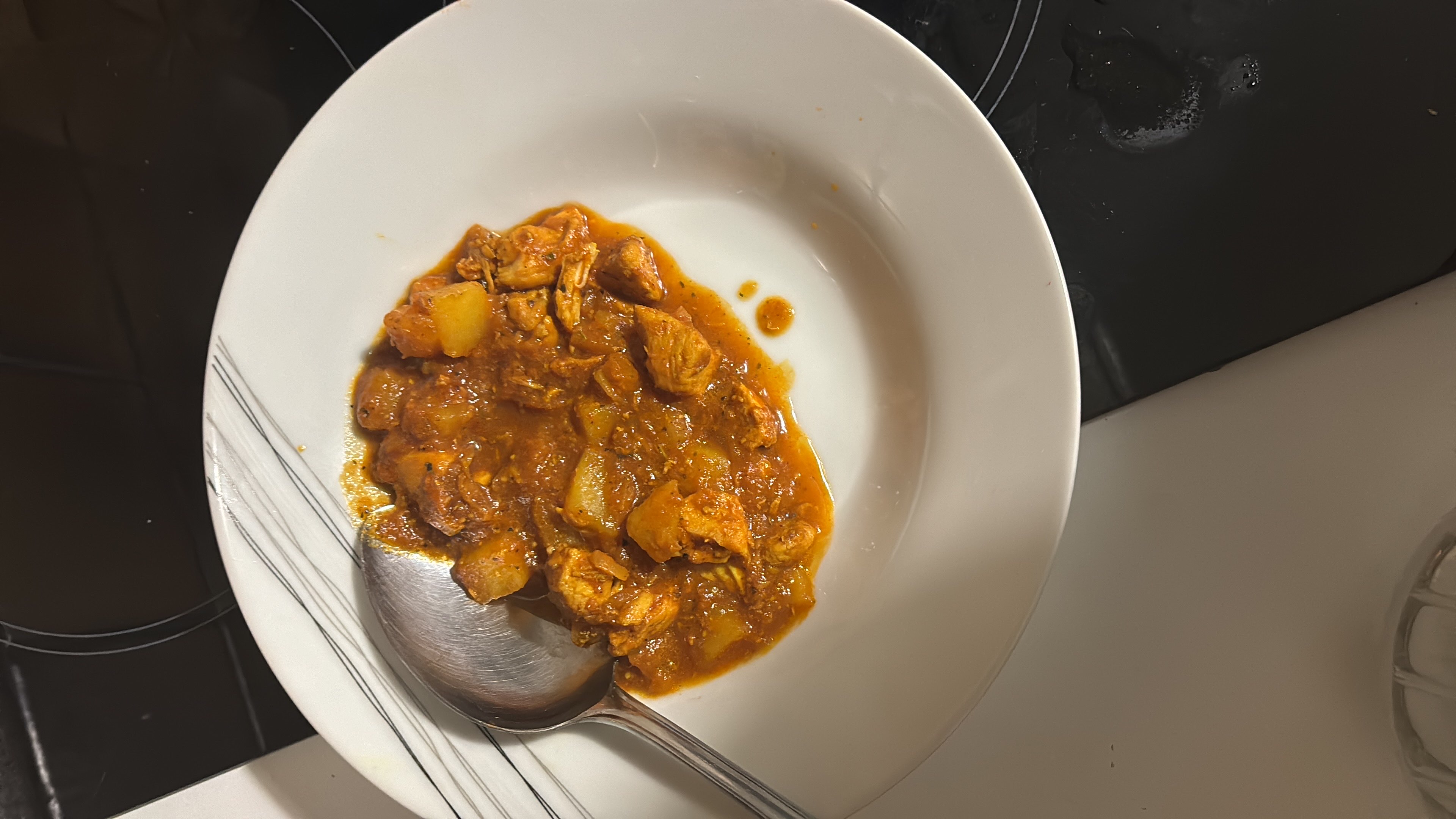 A hearty dish consisting of chicken, potatoes, and tomato-based sauce, providing a balanced mix of protein, carbs, and fats.