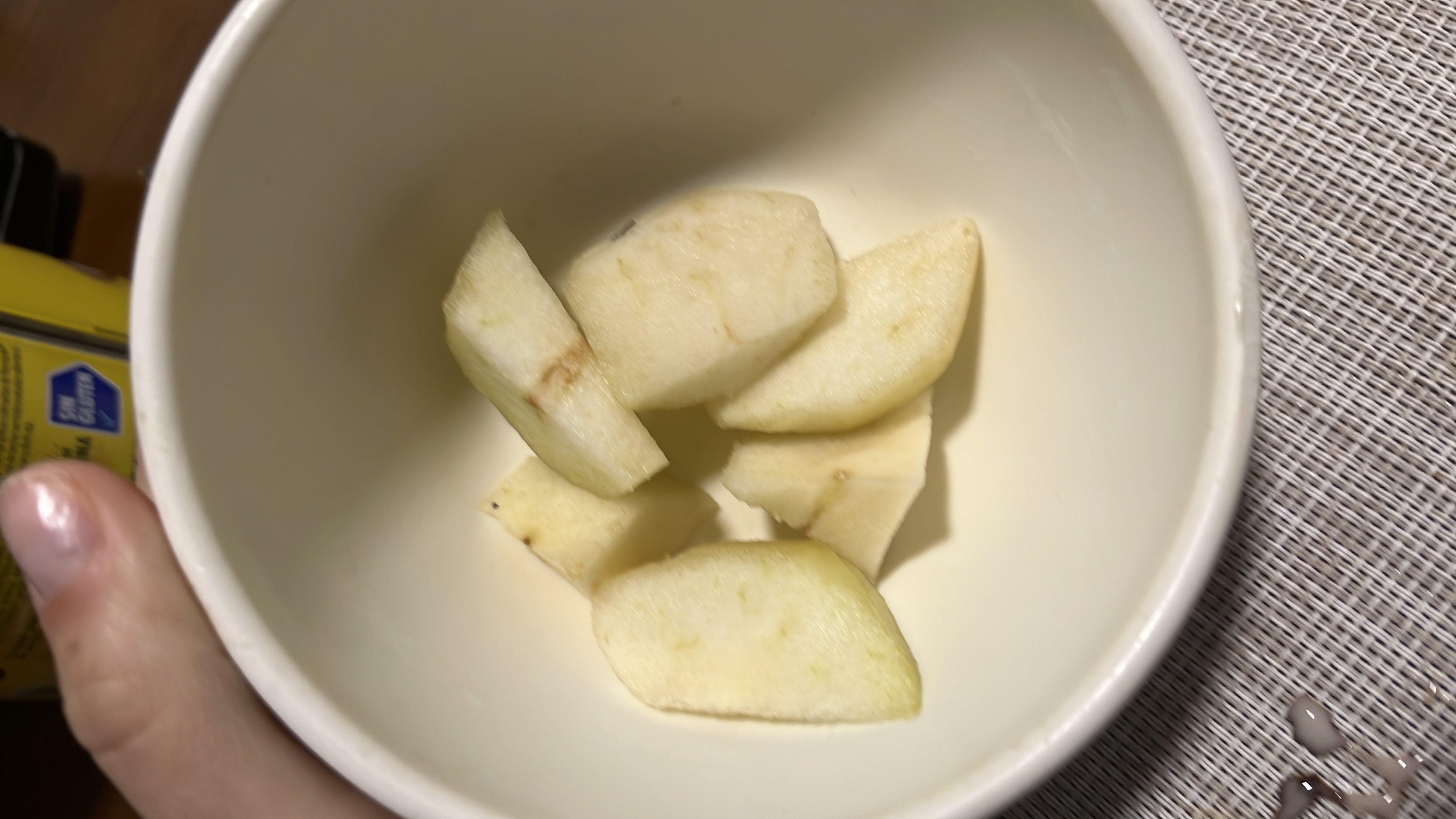 The image shows a bowl containing apple slices, which are low in calories and rich in carbohydrates.