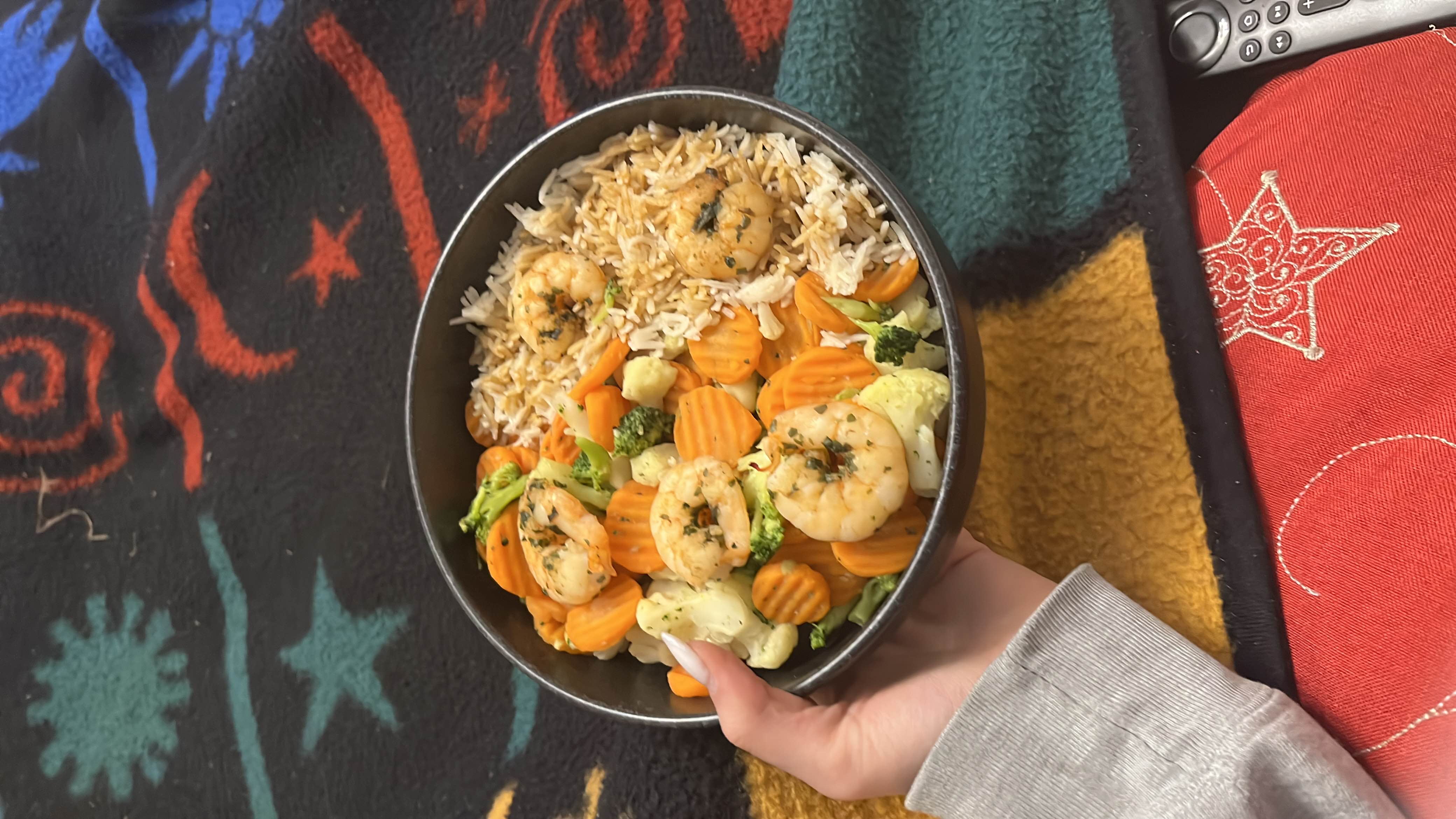A balanced meal consisting of shrimp, rice, and mixed vegetables including carrots, broccoli, and cauliflower.
