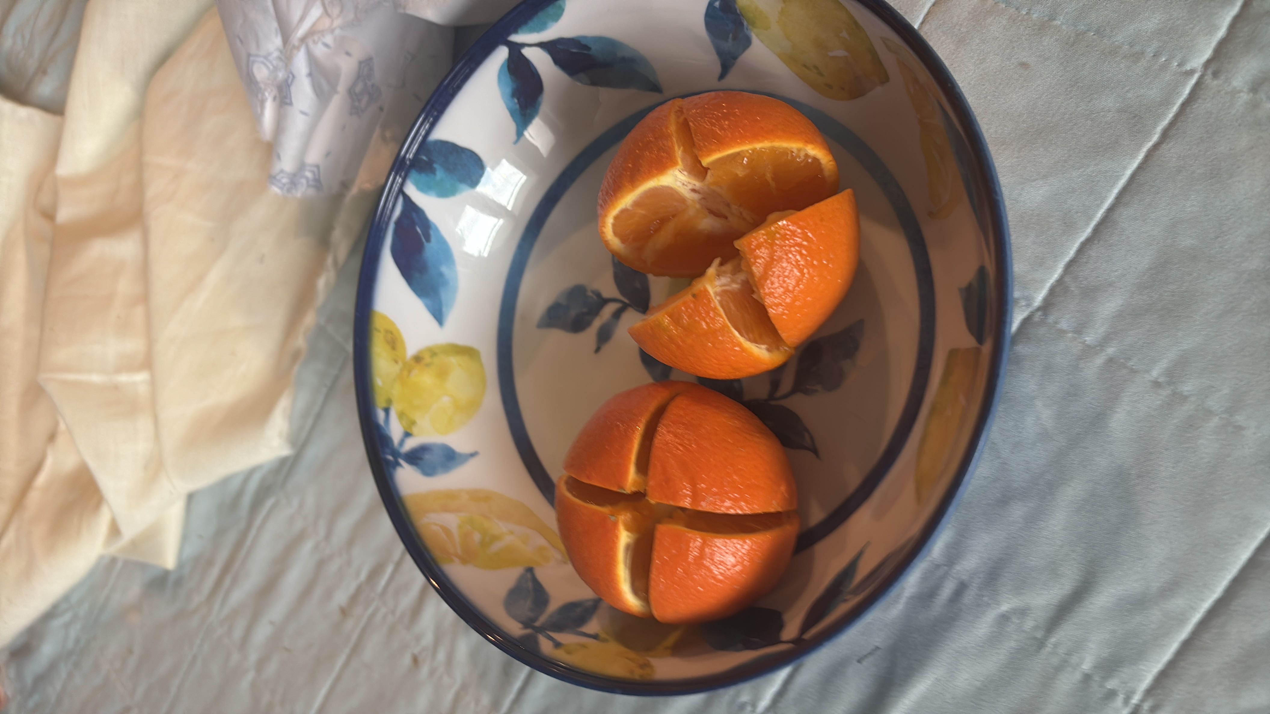 The image shows two sliced oranges in a decorative bowl, providing a healthy and nutritious snack option.