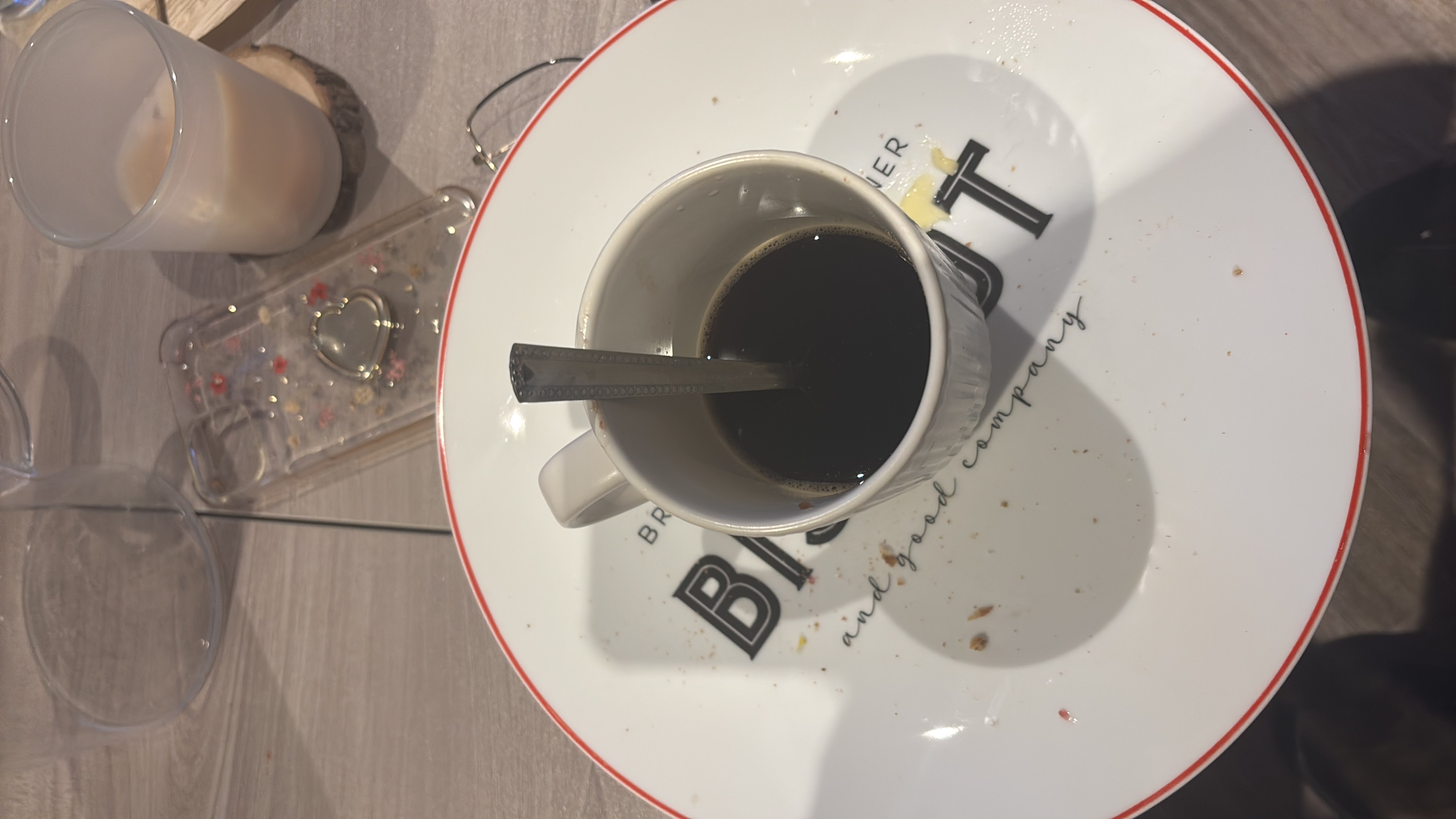 A cup of black coffee served on a plate with minimal crumbs, indicating a low-calorie beverage.