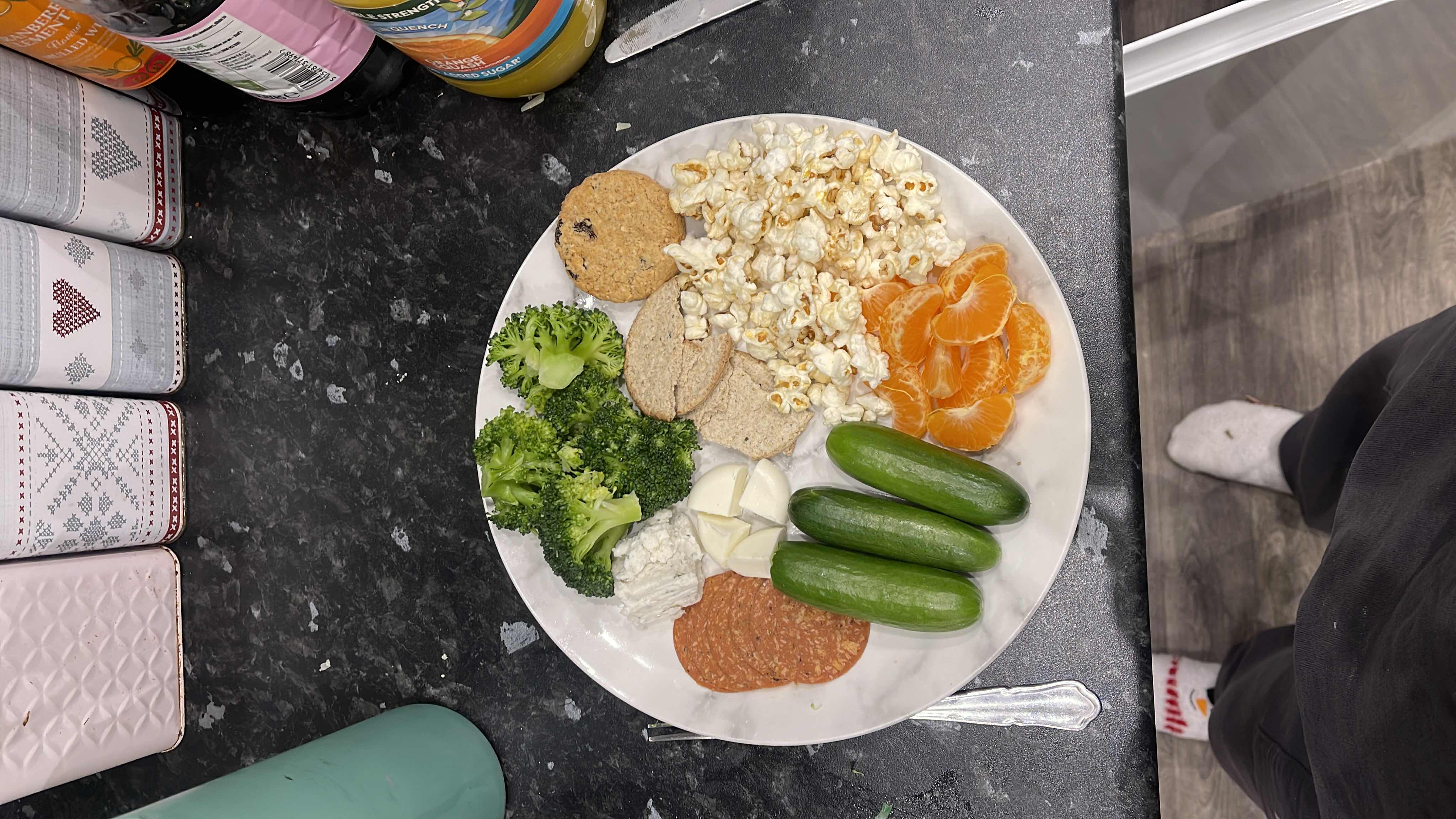A balanced plate containing vegetables, fruits, protein, and snacks, offering a mix of nutrients with a moderate calorie count.