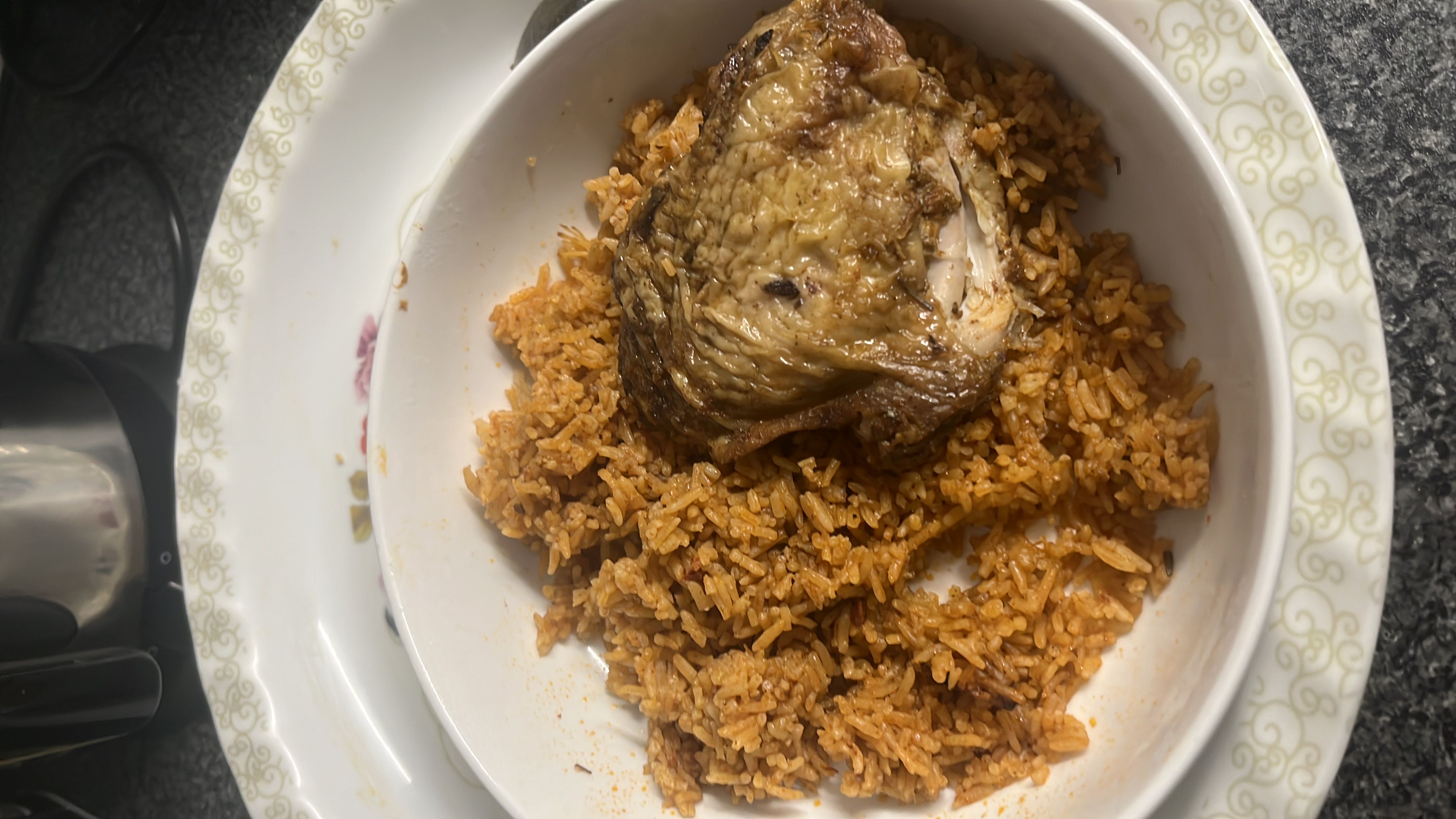 A dish consisting of seasoned rice and a piece of roasted chicken, providing a balanced mix of protein, carbohydrates, and fats.
