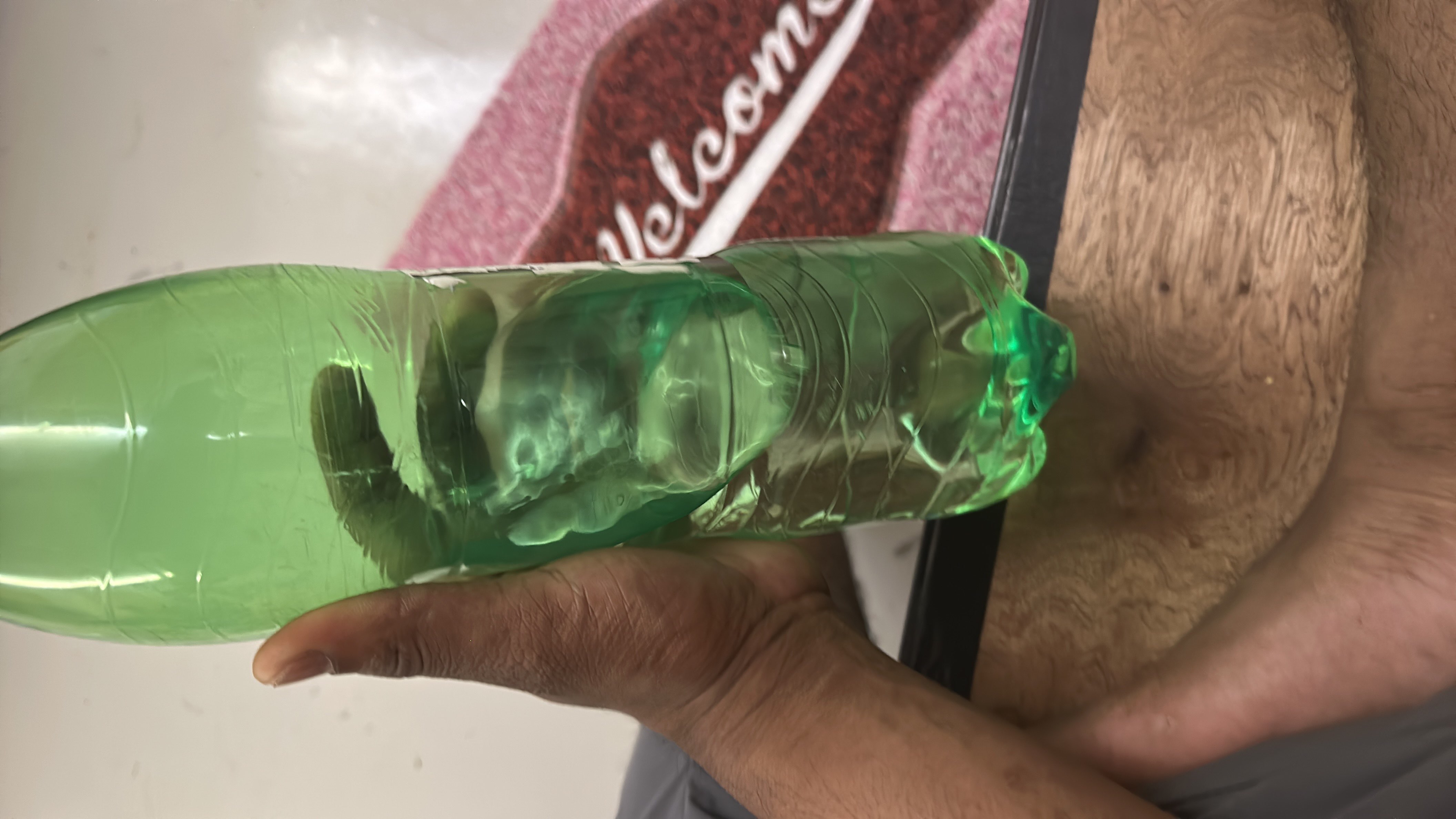 The image shows a green plastic bottle containing water, which has no calories, protein, carbs, or fats.
