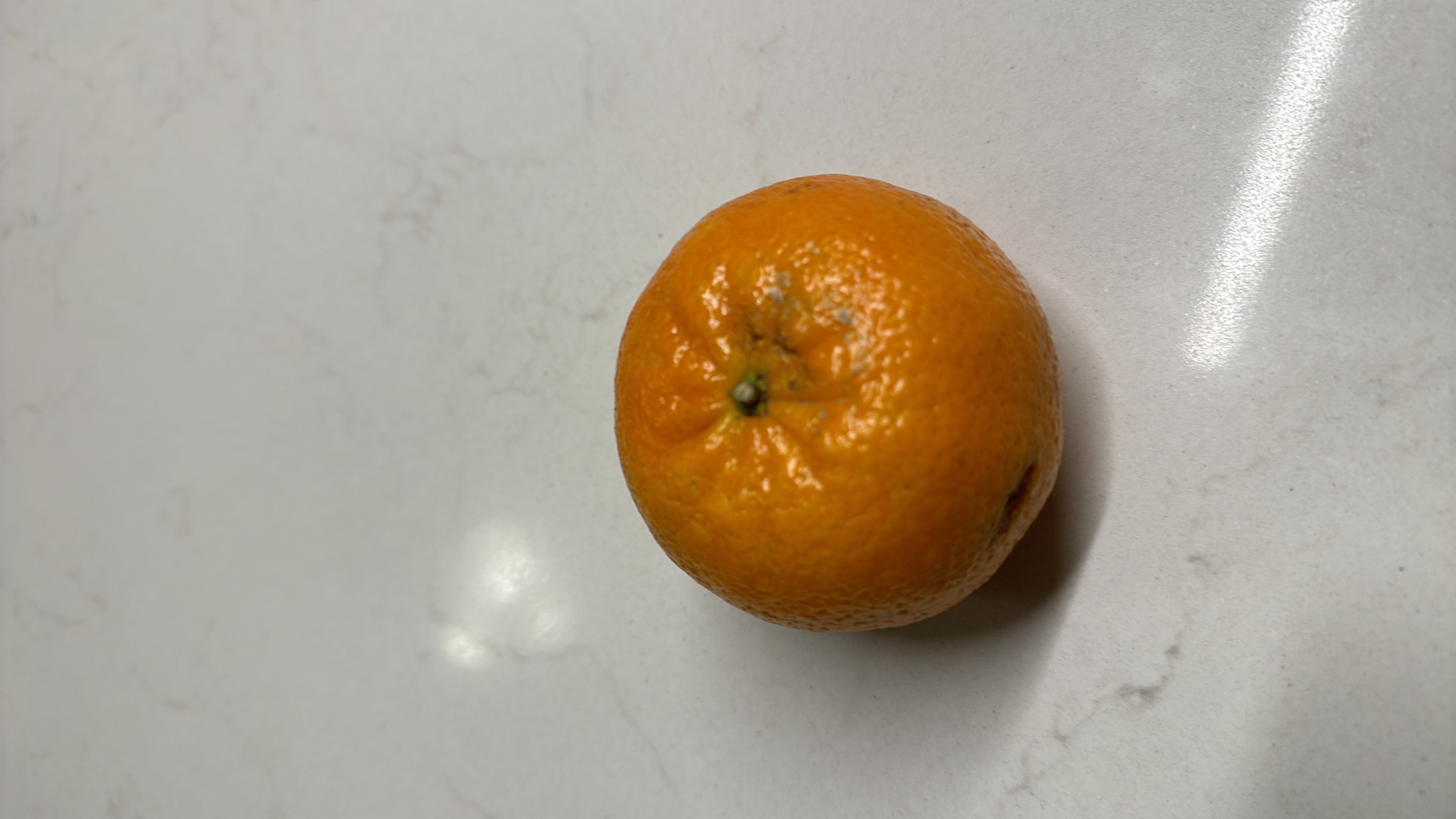 This is a mandarin orange, a low-calorie fruit rich in vitamin C and dietary fiber, making it a healthy snack option.