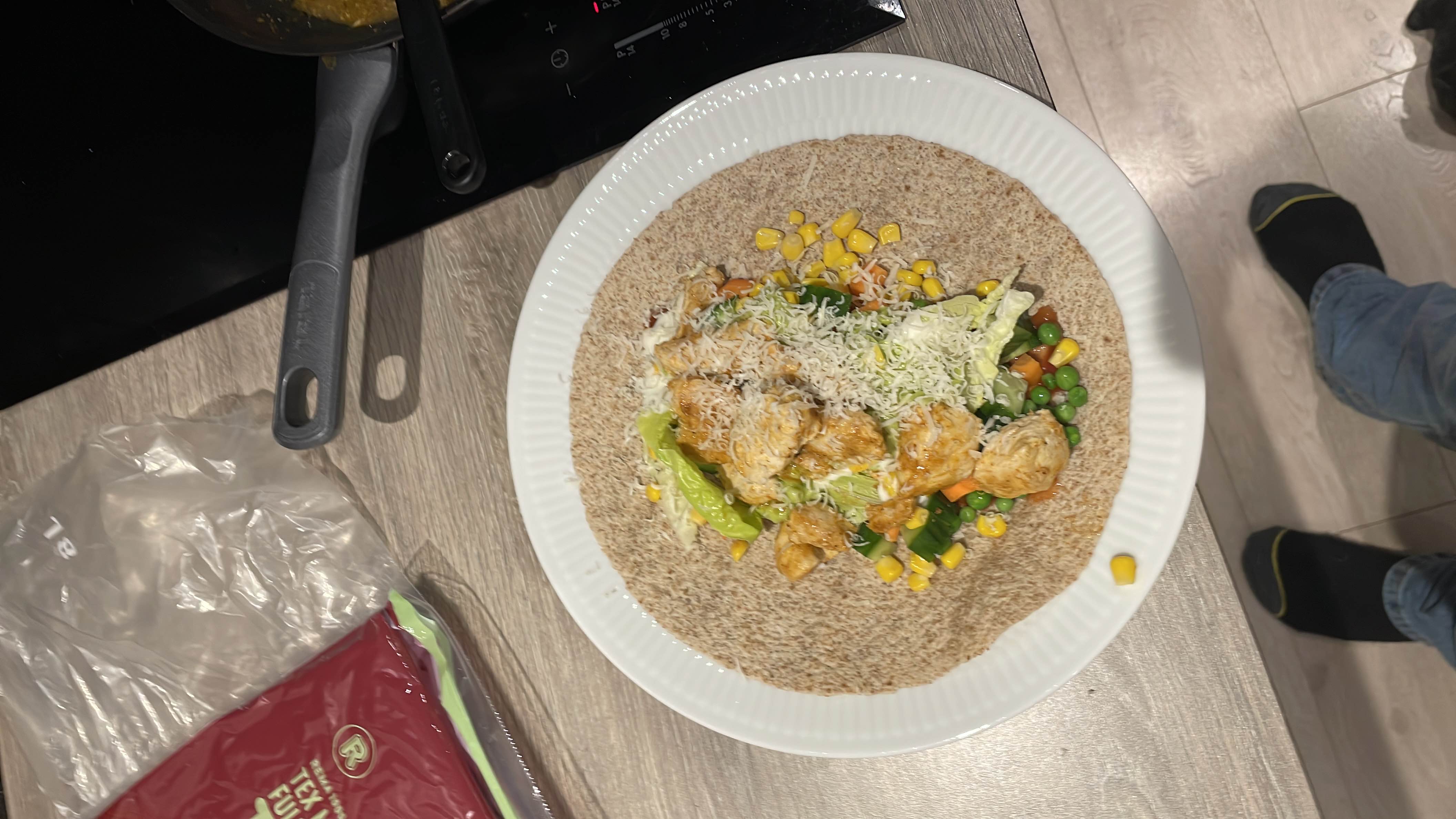 A healthy wrap made with a whole wheat tortilla, grilled chicken, mixed vegetables, and shredded cheese.