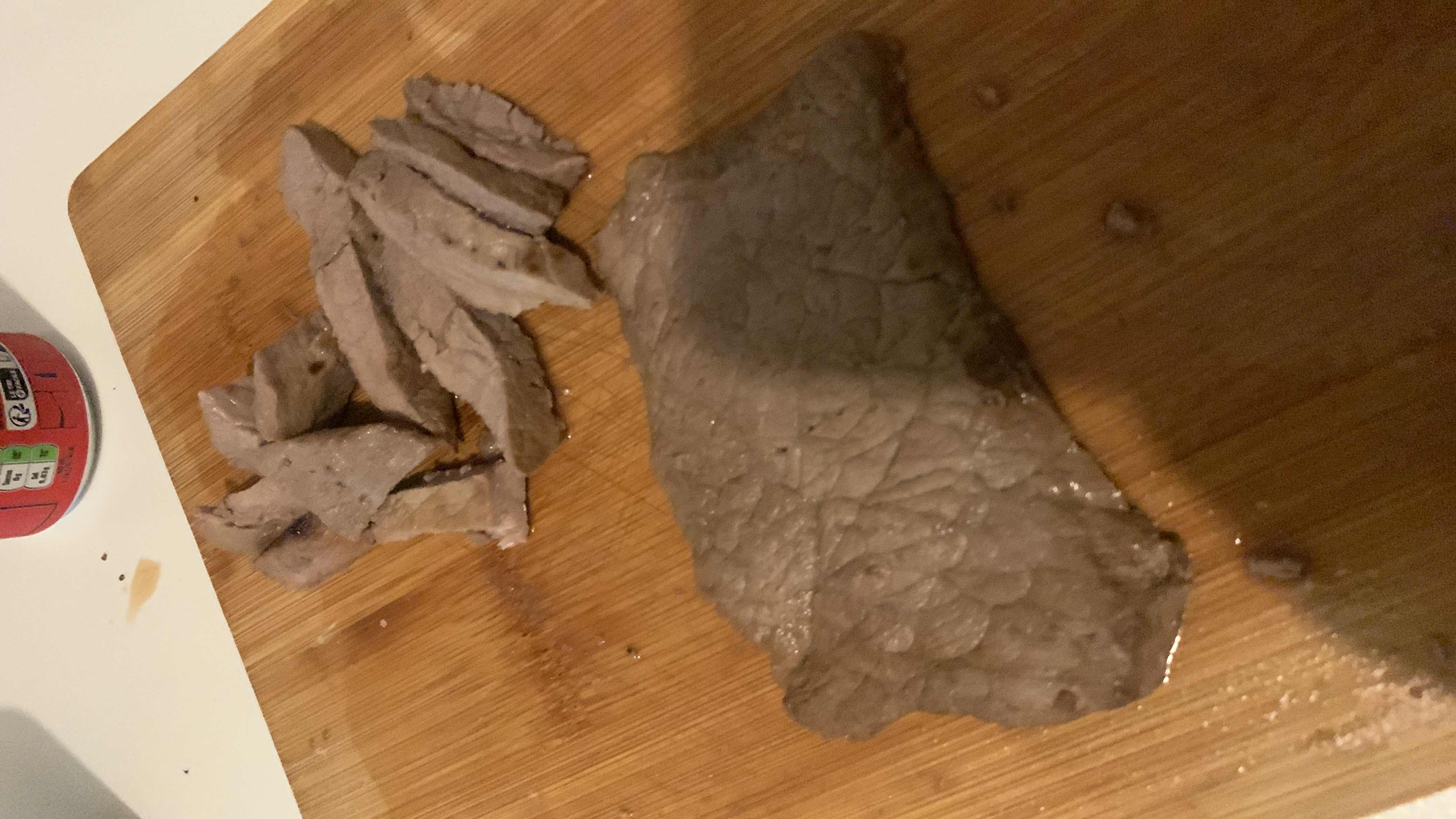 The image shows cooked beef steak slices on a wooden cutting board, providing a high-protein, low-carb meal option.