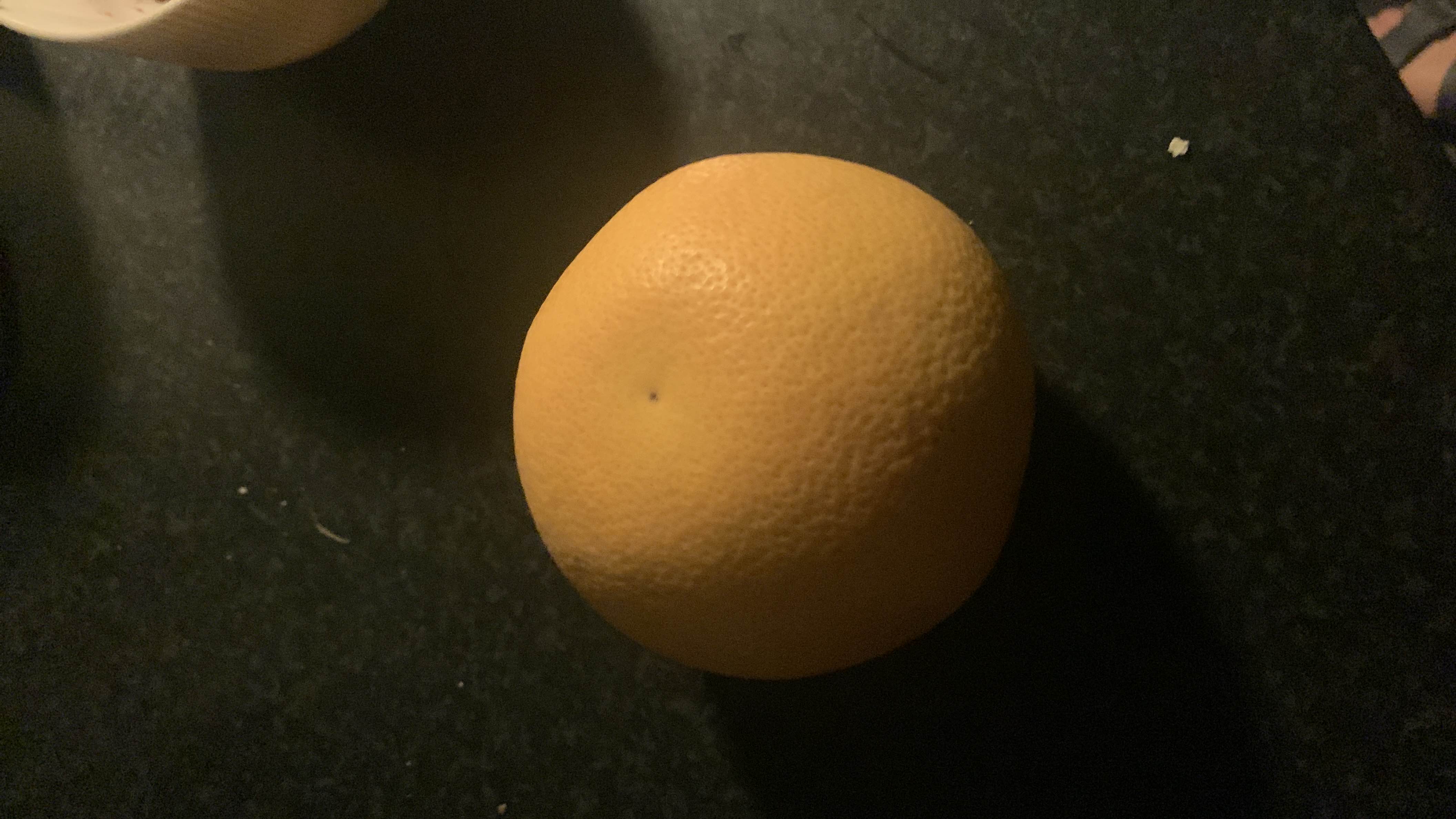 The image shows a grapefruit, a citrus fruit that is low in calories and fats, rich in carbohydrates, and provides a small amount of protein.