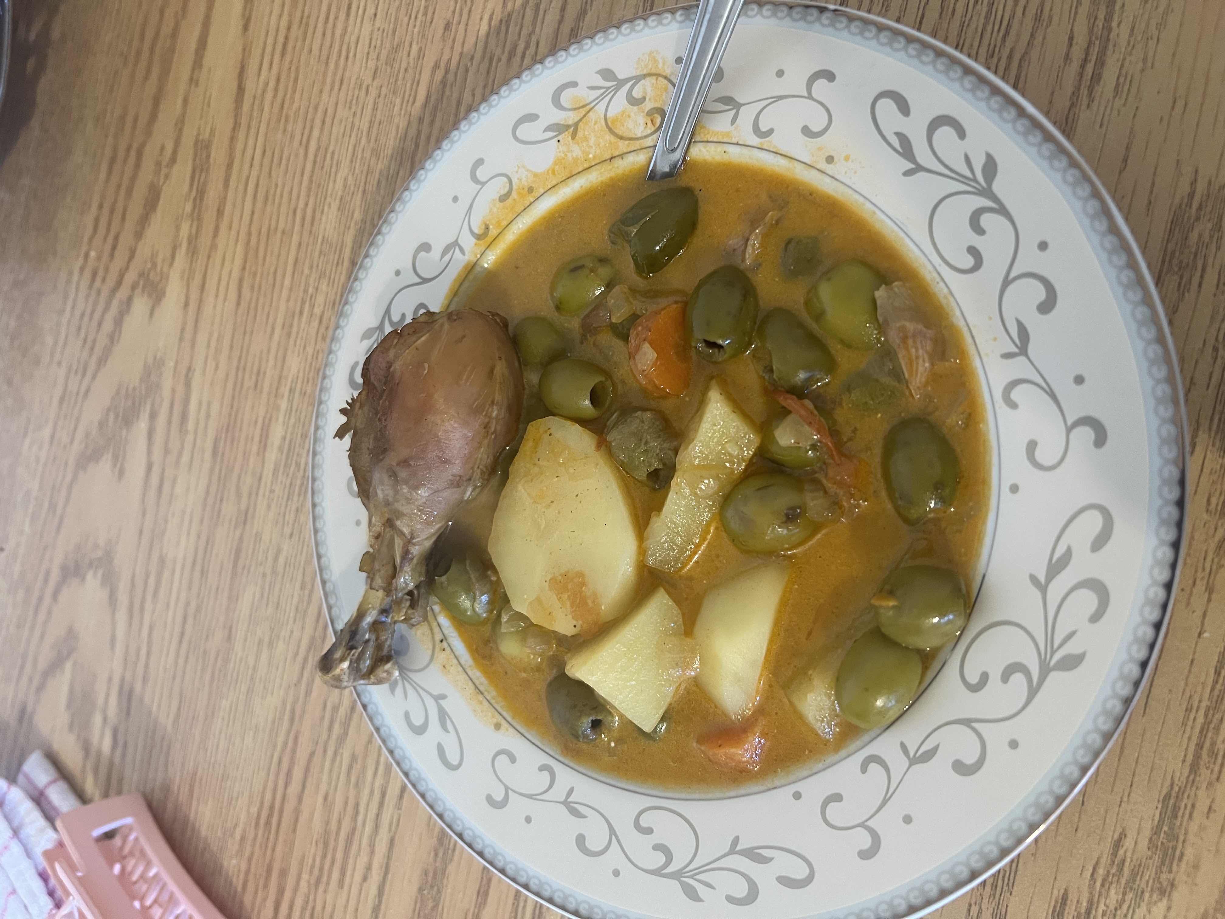 A hearty chicken stew with potatoes, green olives, carrots, and a flavorful broth.