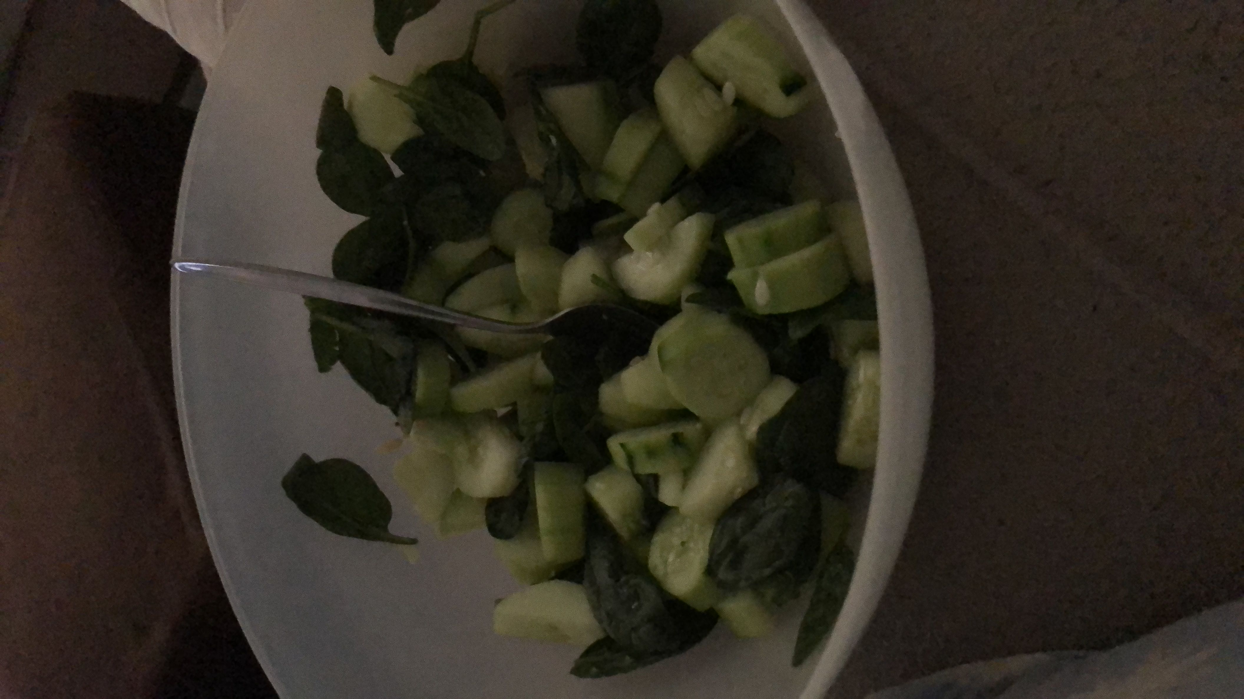 A fresh salad consisting of cucumbers and spinach, low in calories and high in nutritional value.