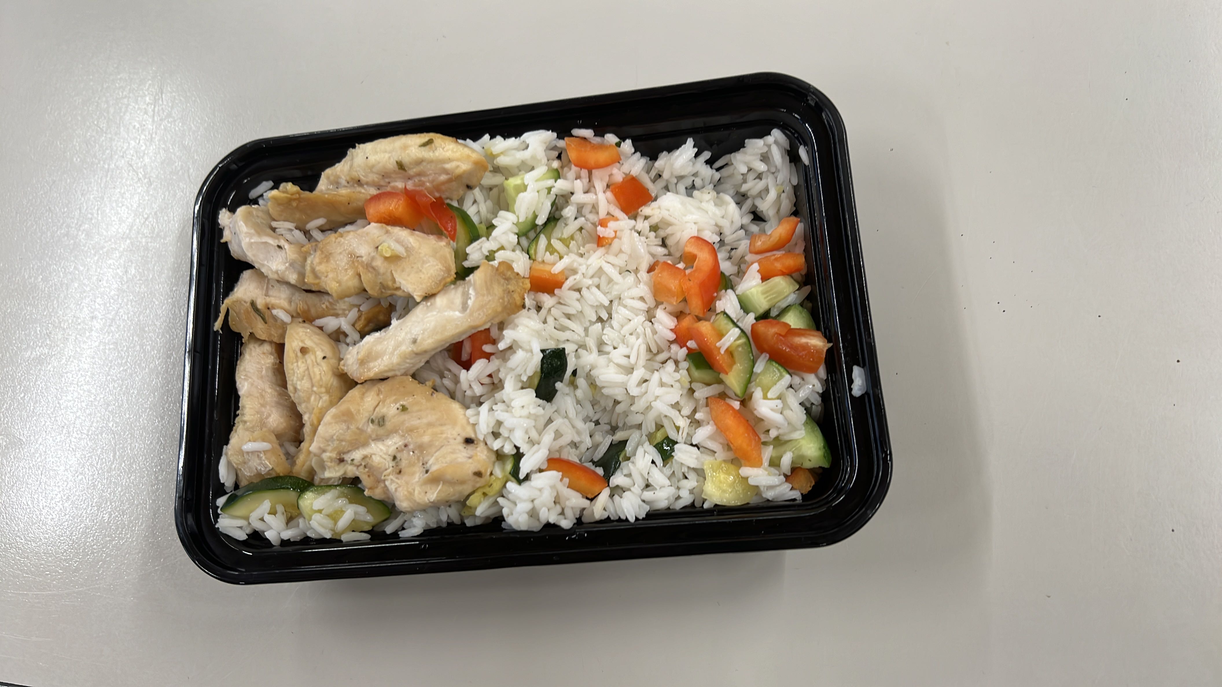 A balanced meal consisting of grilled chicken breast, white rice, and mixed vegetables, providing a good source of protein, carbohydrates, and essential nutrients.