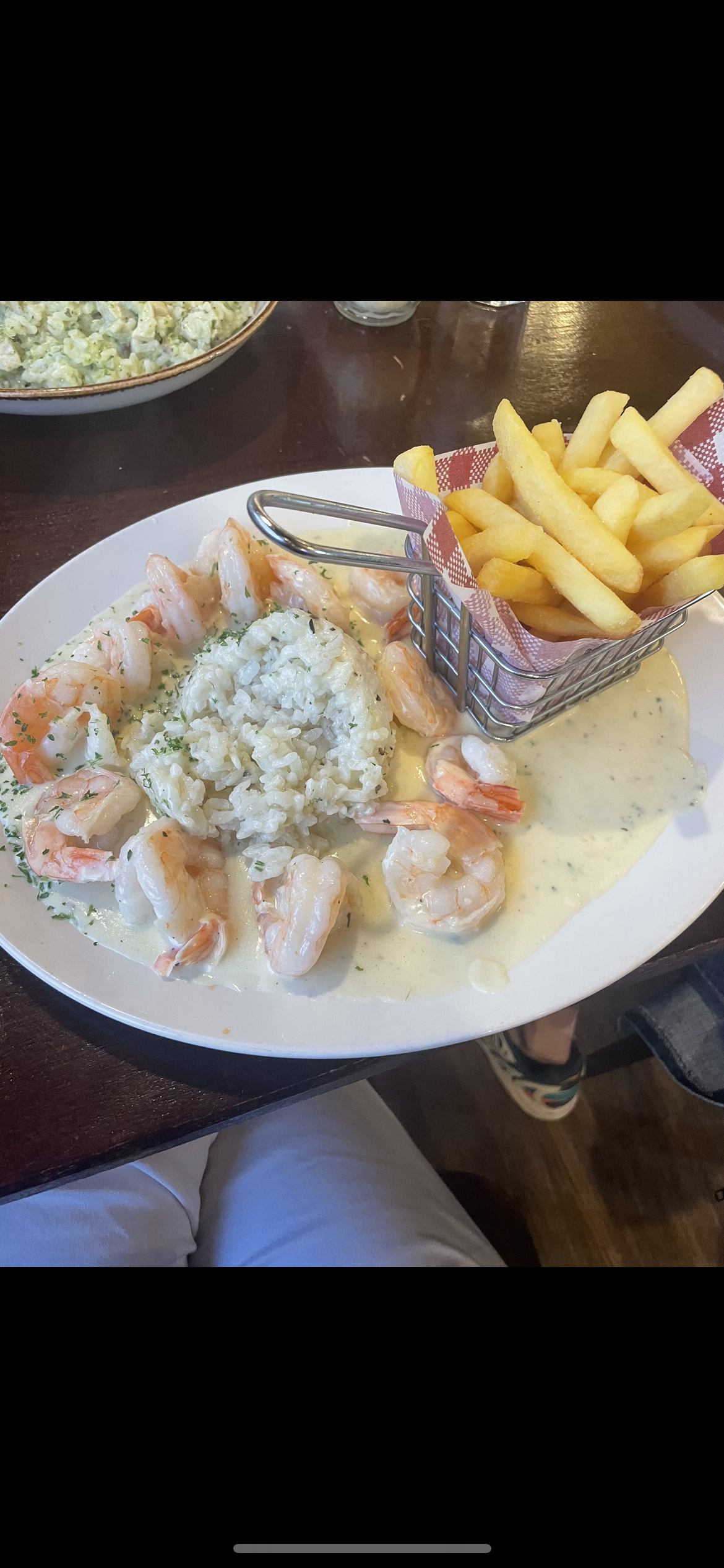 A dish consisting of shrimp in cream sauce, served with rice and a side of french fries.