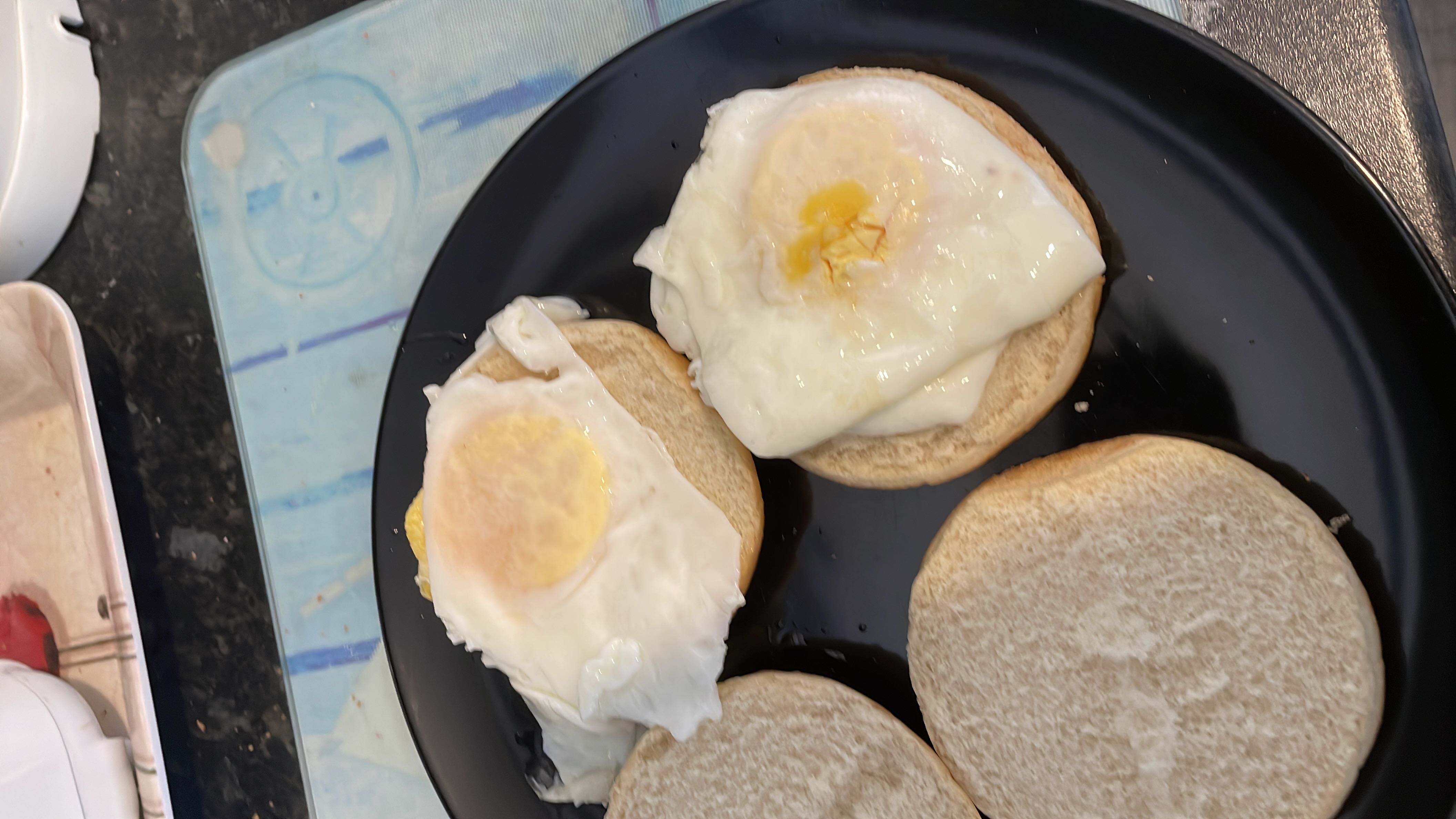 The image shows a meal consisting of fried eggs served on bread buns, providing a balanced mix of protein, carbs, and fats.