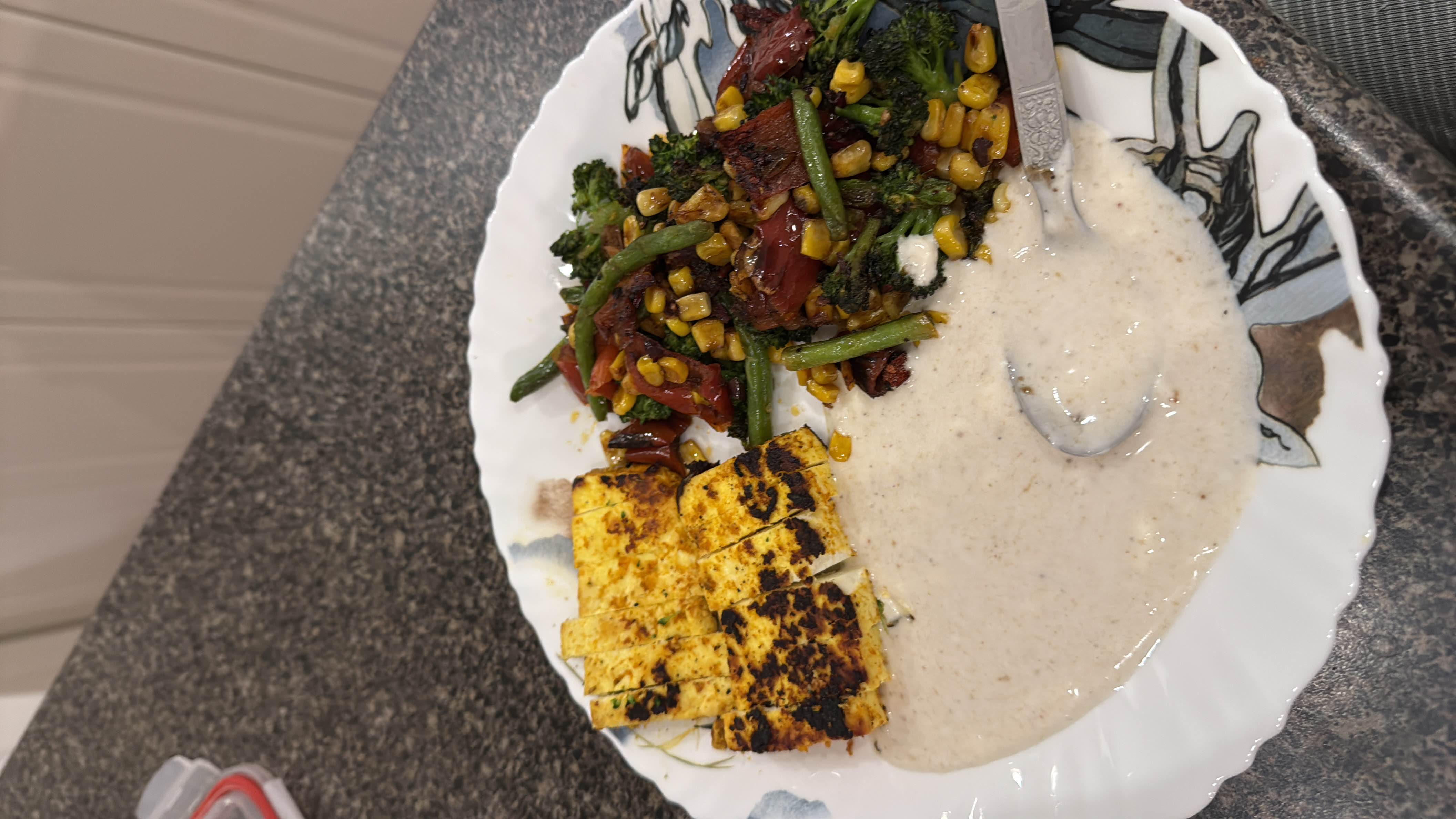 A balanced meal consisting of grilled paneer, sautéed mixed vegetables, and a yogurt-based sauce.