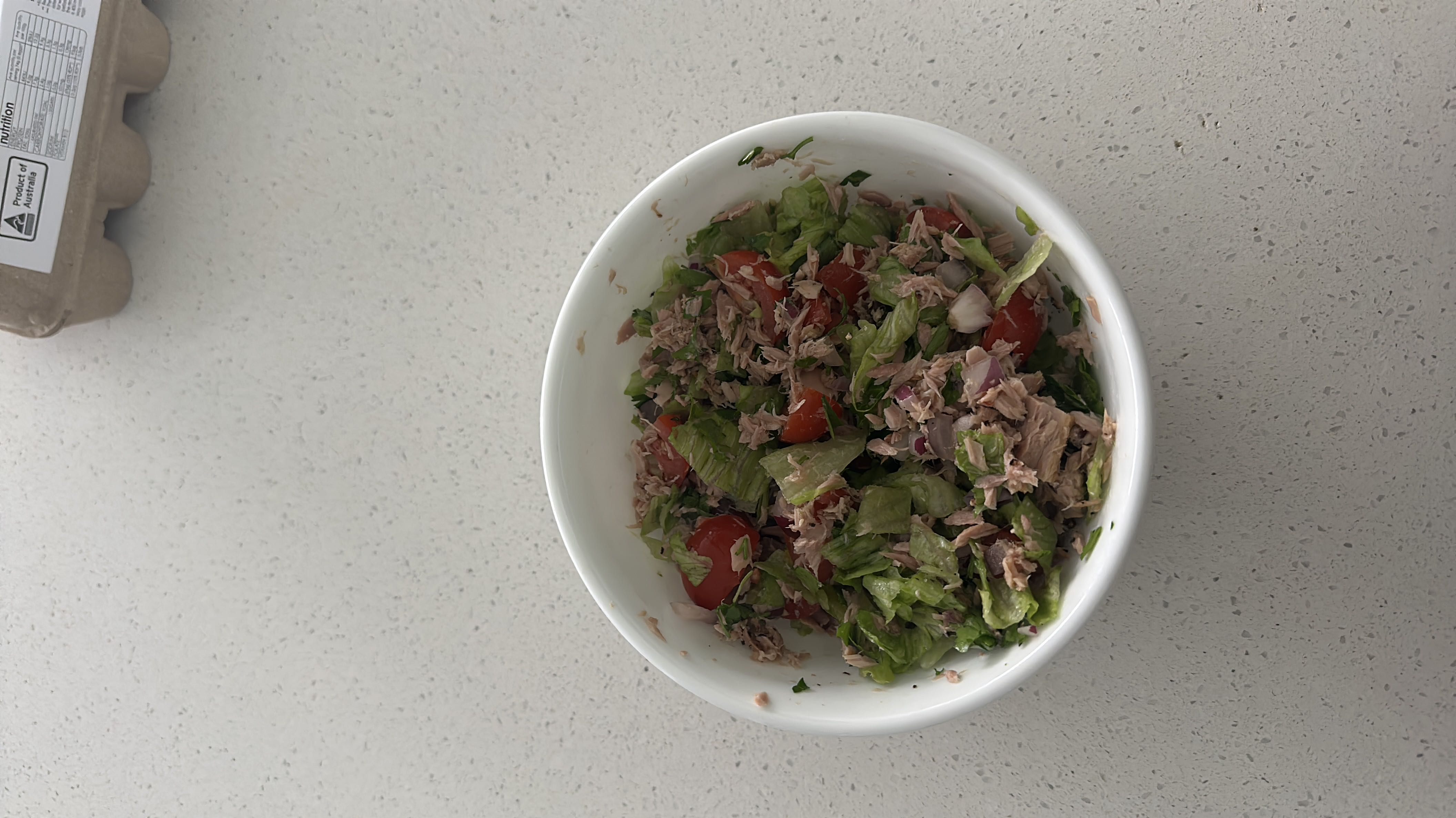 A healthy tuna salad with lettuce, cherry tomatoes, onions, lemon juice, salt, and pepper, providing a balanced mix of protein, carbs, and fats.
