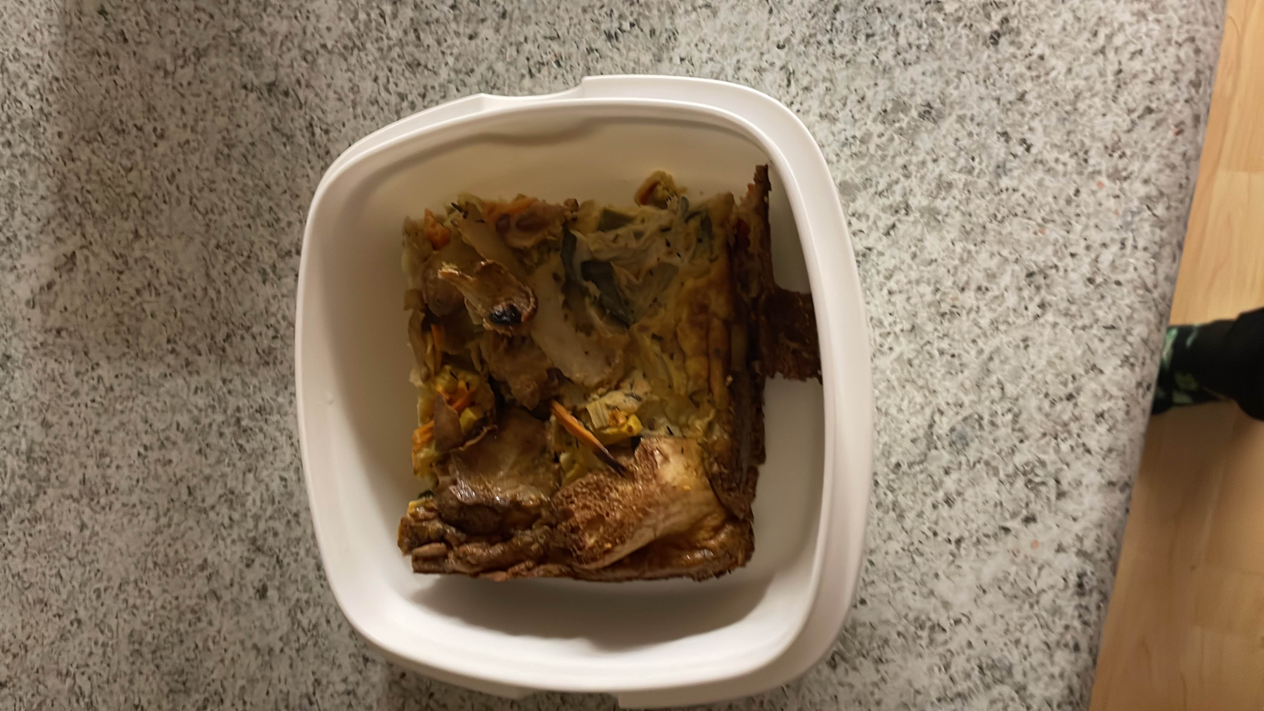 A dish containing chicken, mixed vegetables, and egg, likely baked or fried.