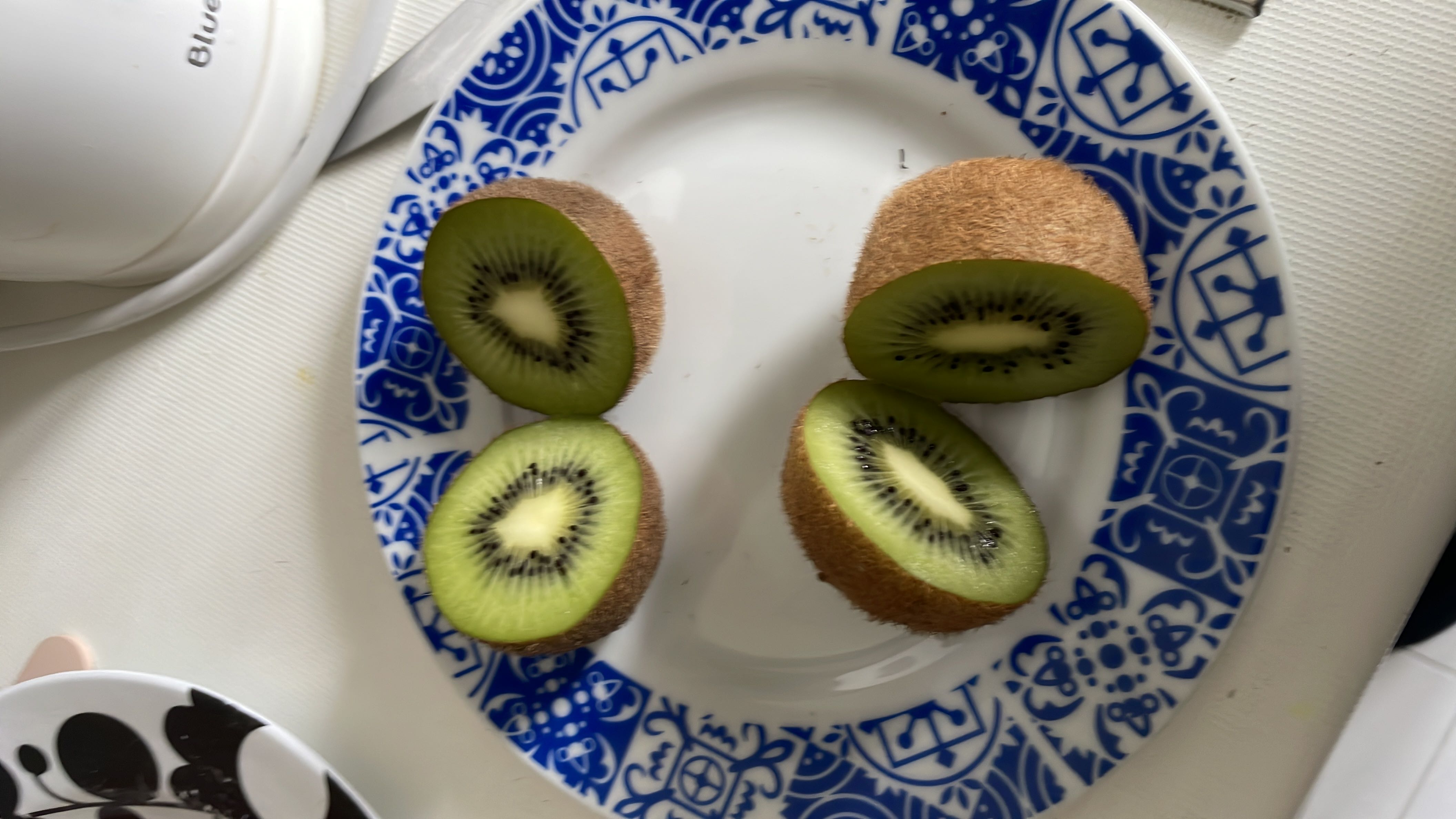The image shows a plate with sliced kiwis, a nutrient-rich fruit high in vitamin C and dietary fiber.