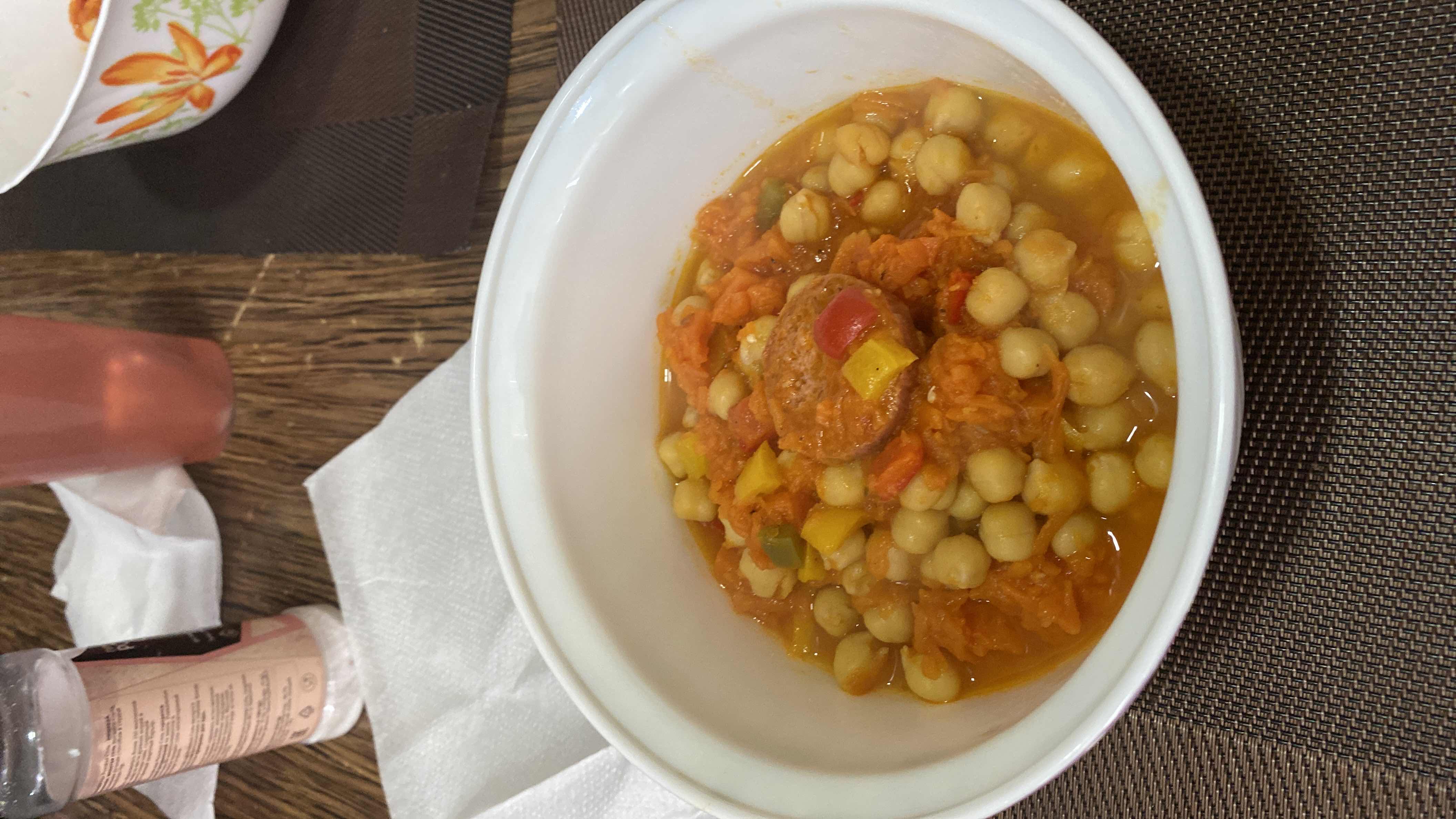 A hearty dish featuring chickpeas, sausage, and mixed vegetables in a flavorful broth.