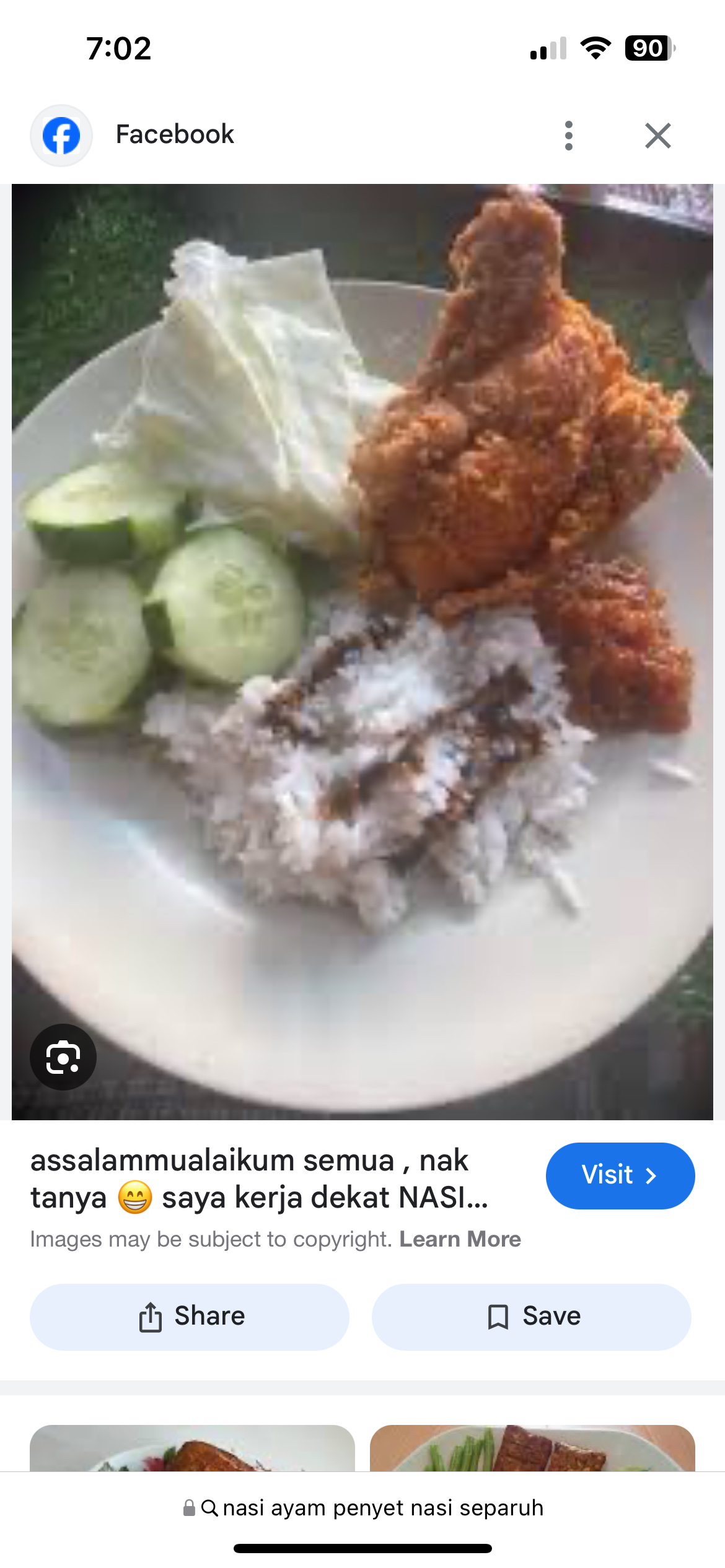 A plate of nasi ayam penyet consisting of fried chicken, rice, cucumber, cabbage, and soy sauce.