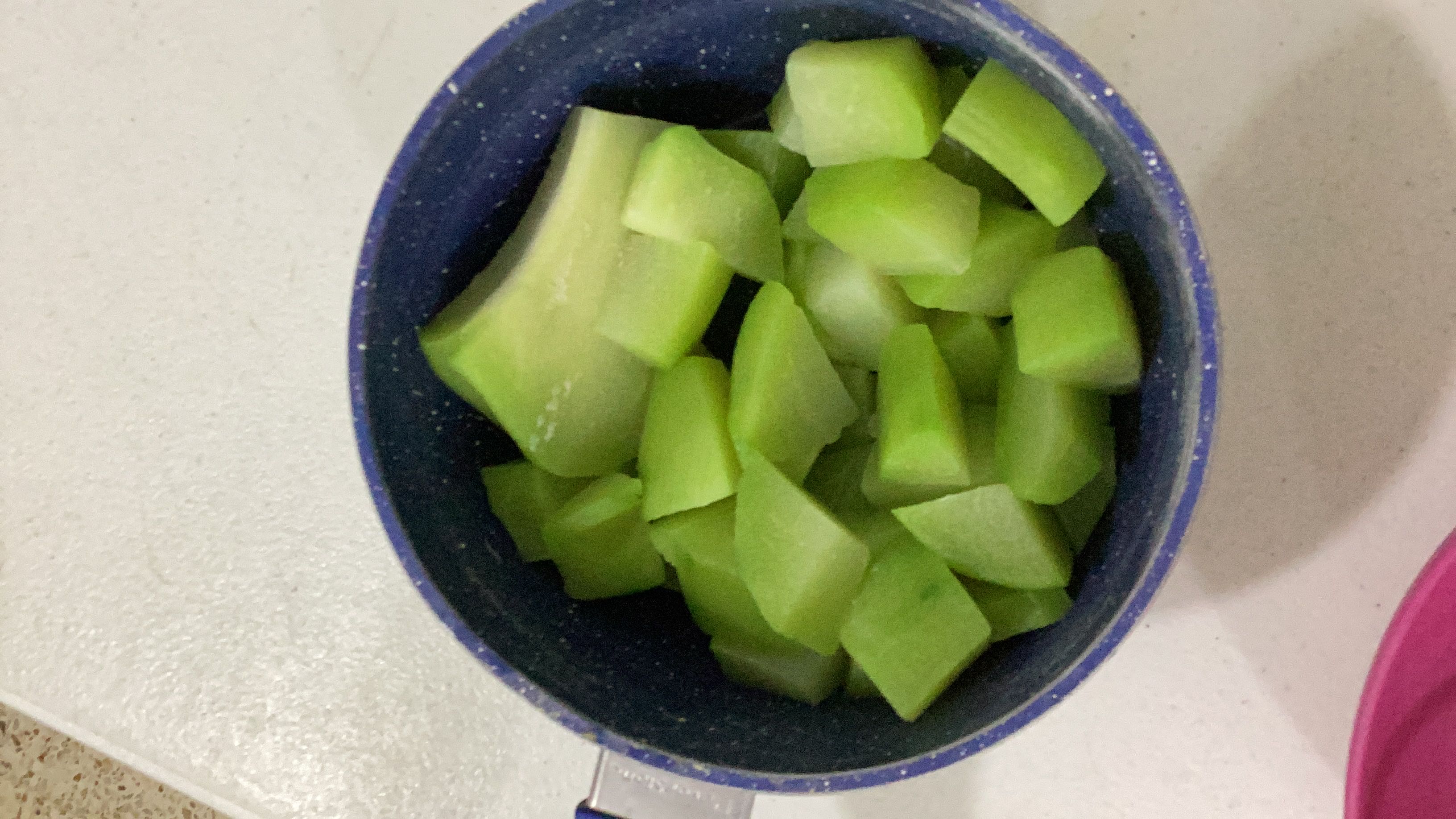 The image shows a bowl of chopped chayote, a low-calorie vegetable rich in water and fiber.
