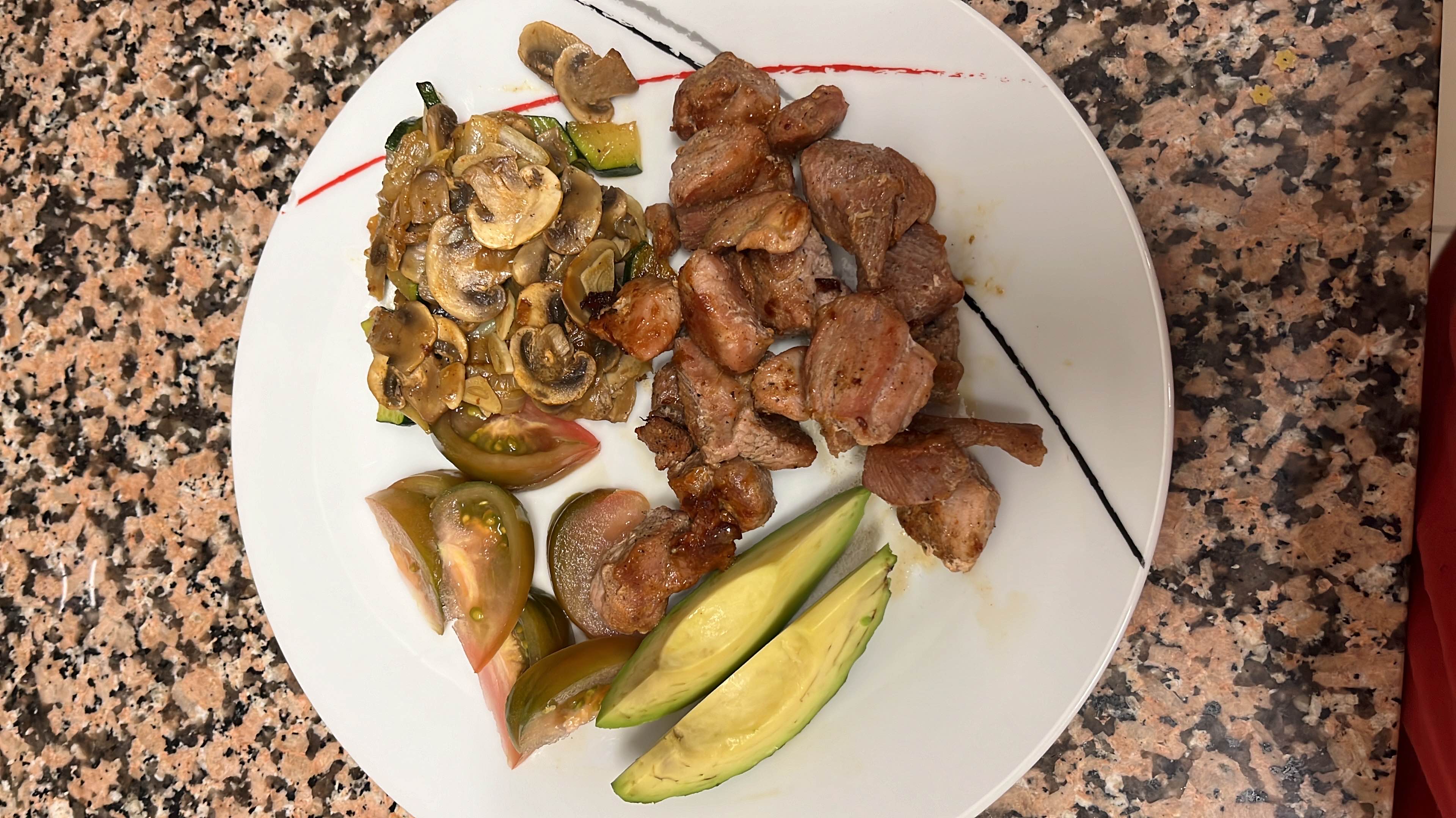 A balanced plate featuring grilled turkey, avocado slices, fresh tomato, sautéed mushrooms, zucchini, onion, and garlic, offering a nutritious meal.