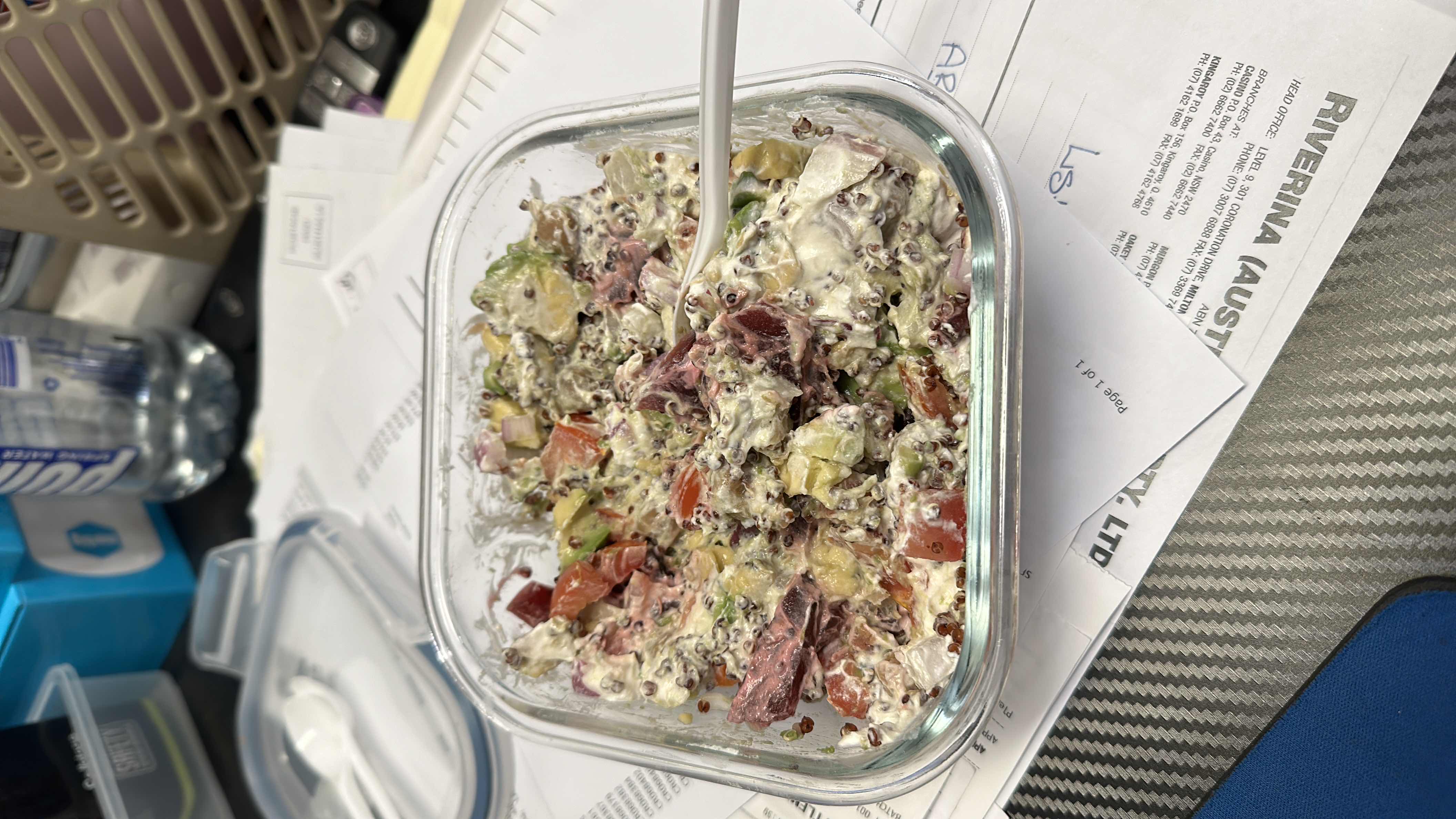 A healthy quinoa salad with tomatoes, avocado, onions, and a yogurt-based dressing.