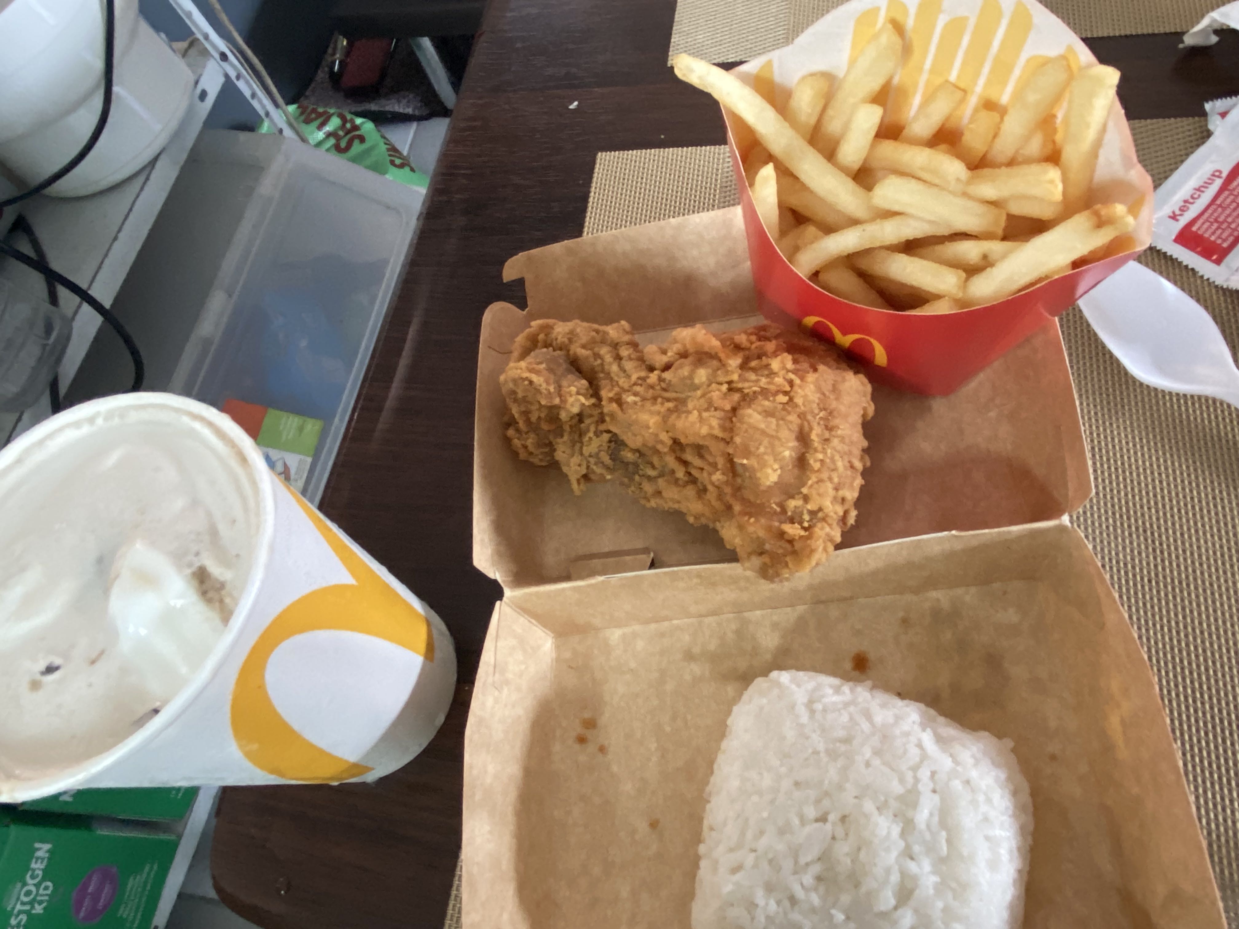 A meal consisting of fried chicken, rice, french fries, and a soft drink, providing a high-calorie fast food option.
