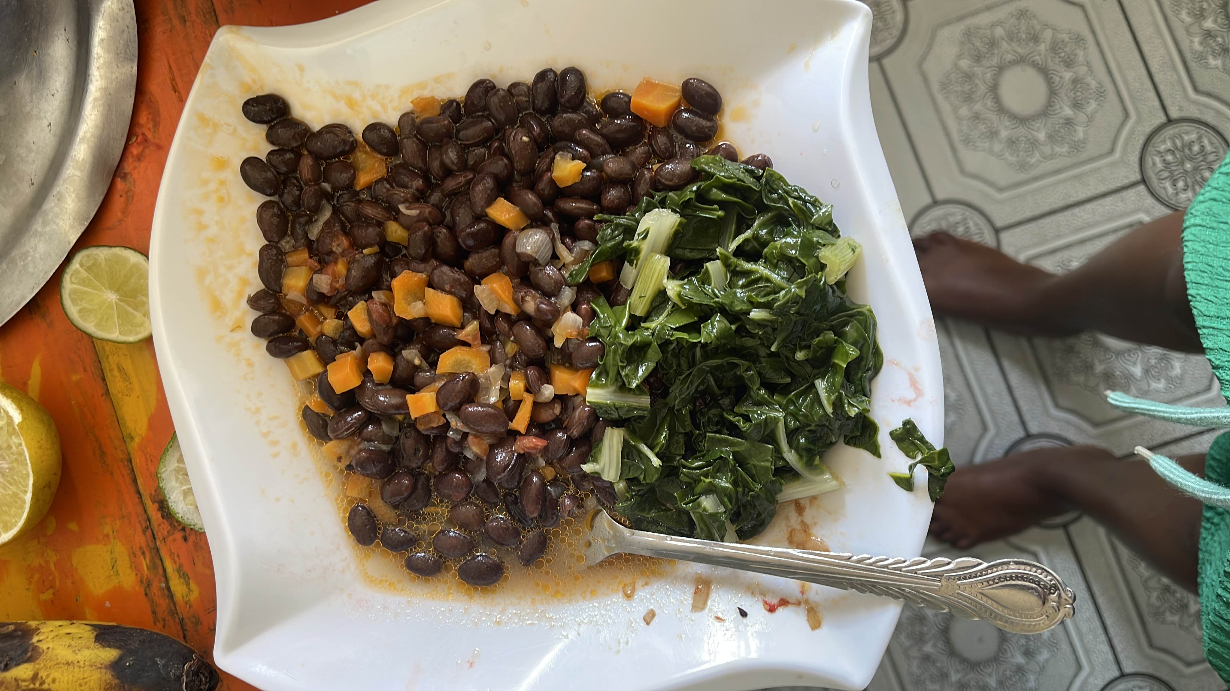 A nutritious meal consisting of black beans, steamed greens, and diced carrots, providing a balanced mix of protein, carbs, and fiber.