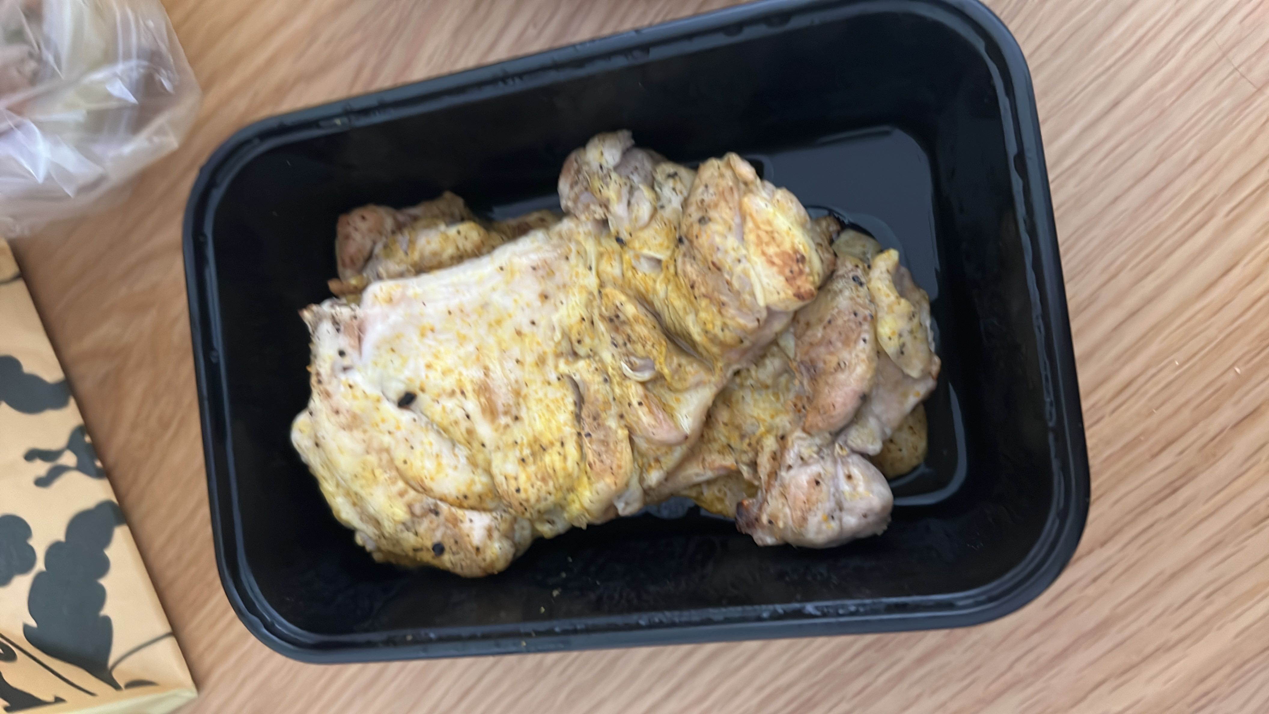 The image shows a container of cooked chicken breast, a high-protein, low-carb food option.