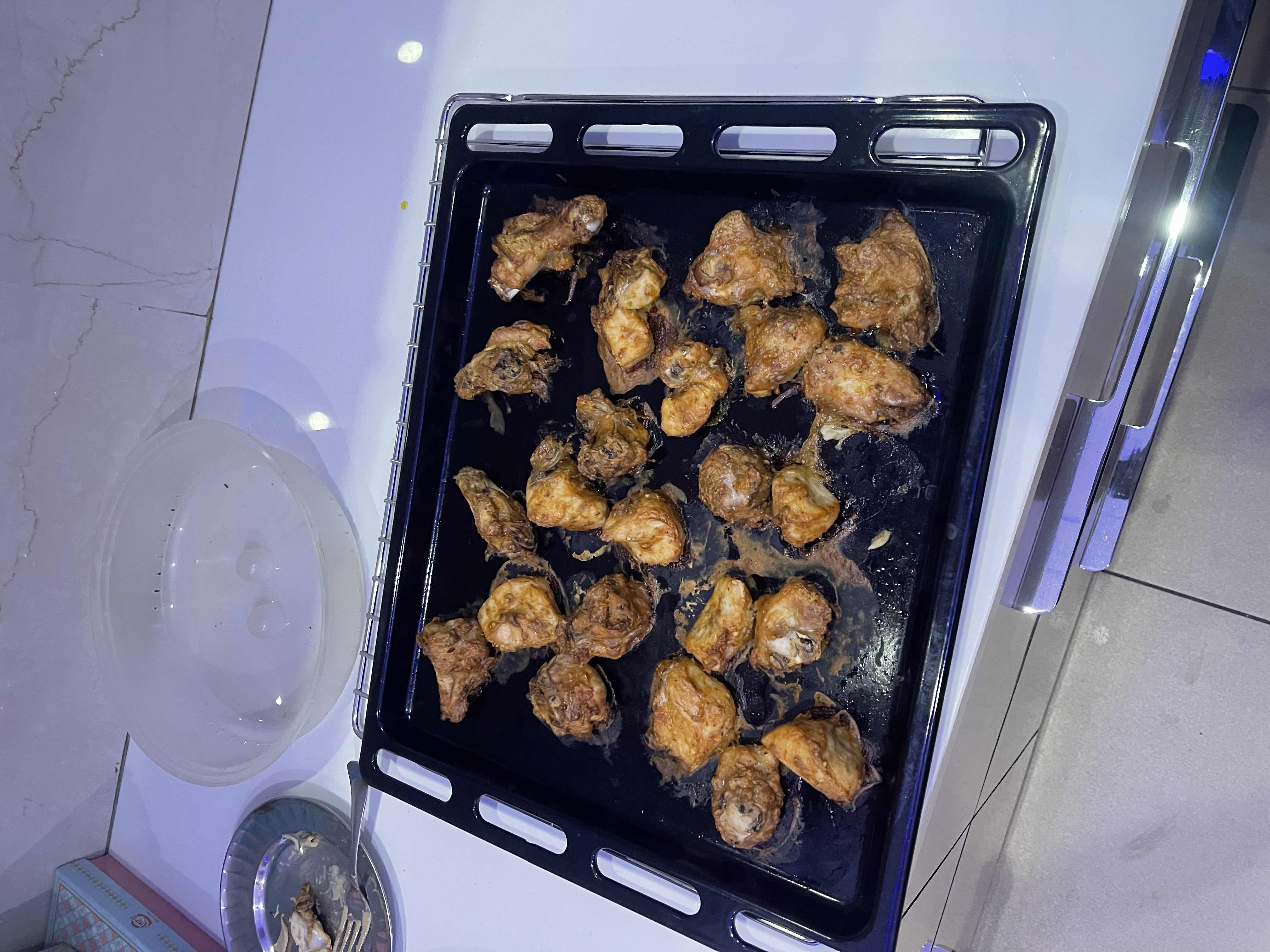 The image shows a tray of baked chicken wings, which are high in protein and fats with minimal carbohydrates.