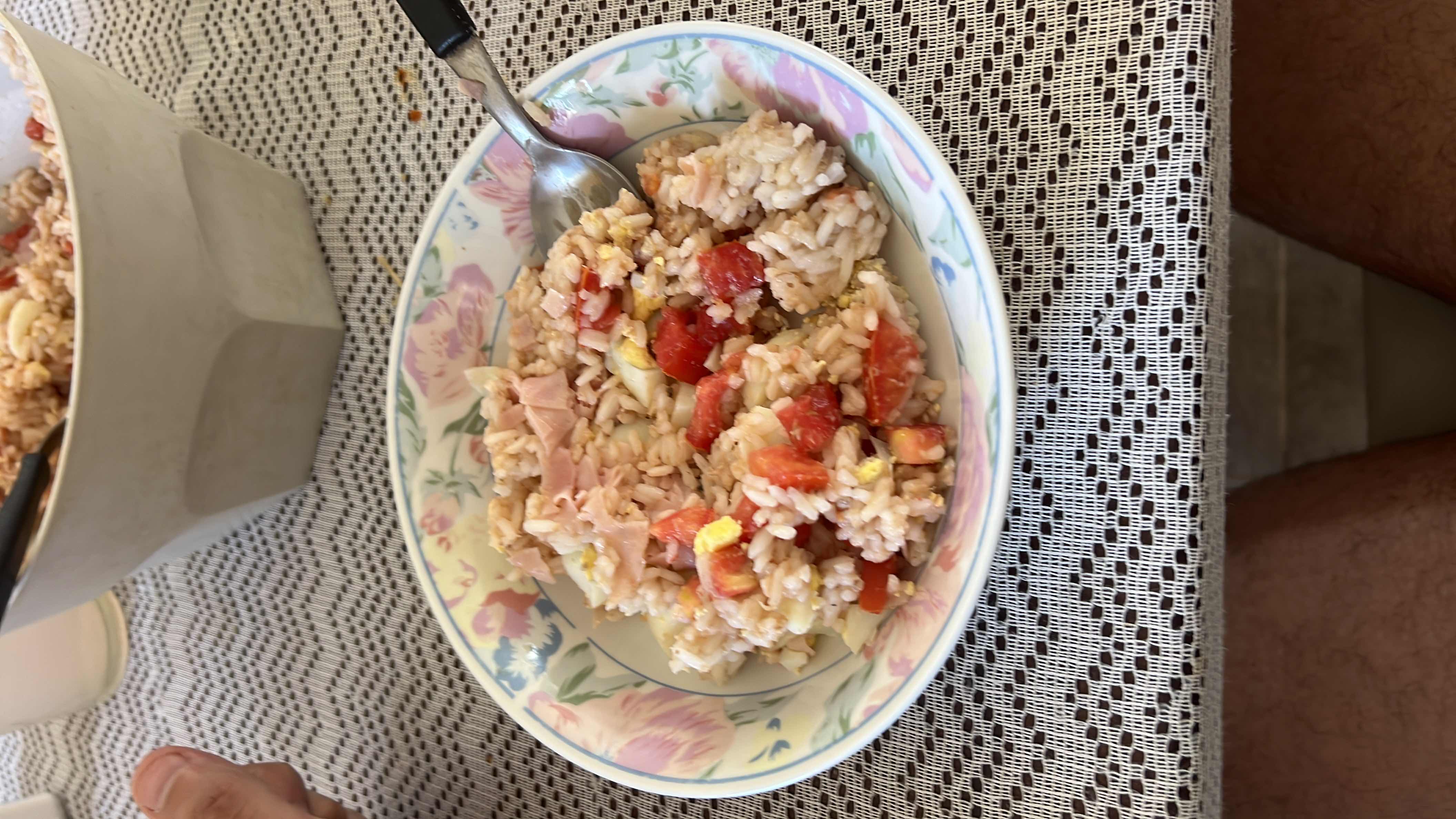 A bowl of rice mixed with diced tomatoes, ham, and egg, providing a balanced meal with moderate calories and a good health score.