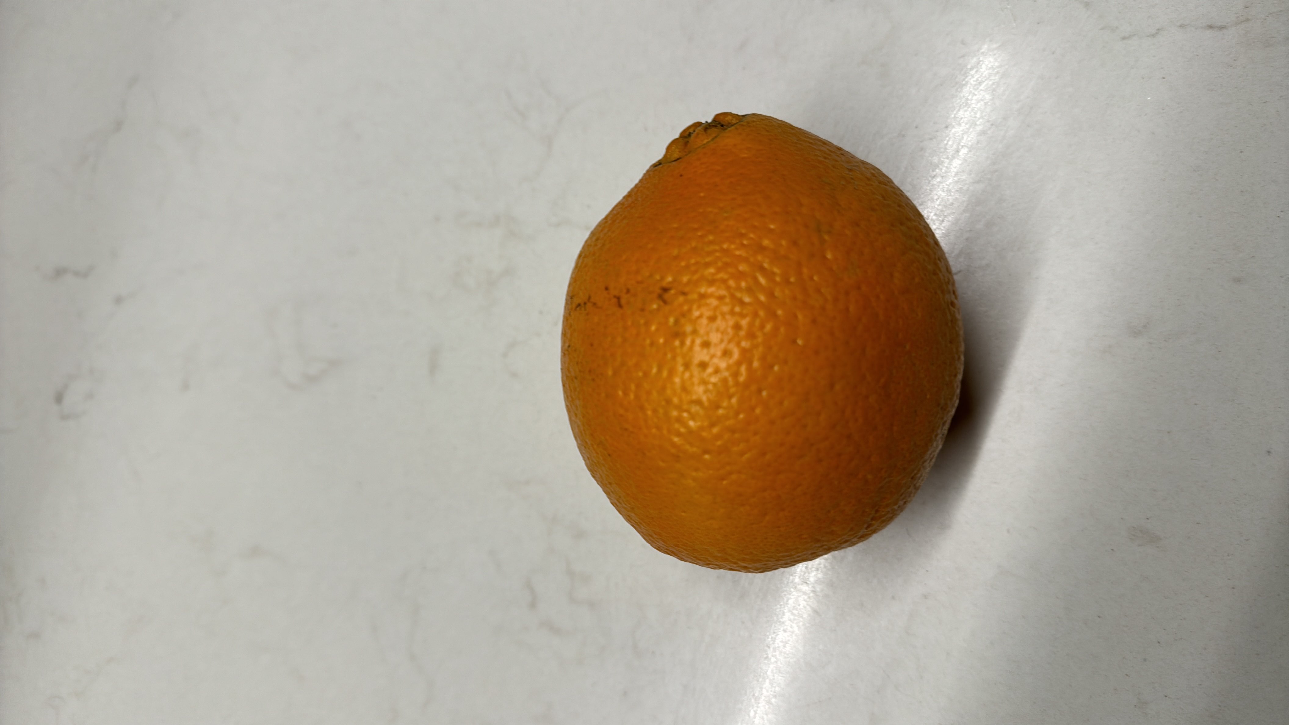 The image shows an orange, a citrus fruit rich in vitamin C, with moderate calories and high health benefits.