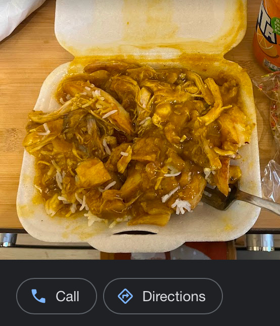 A meal consisting of shredded chicken in curry sauce served over white rice.