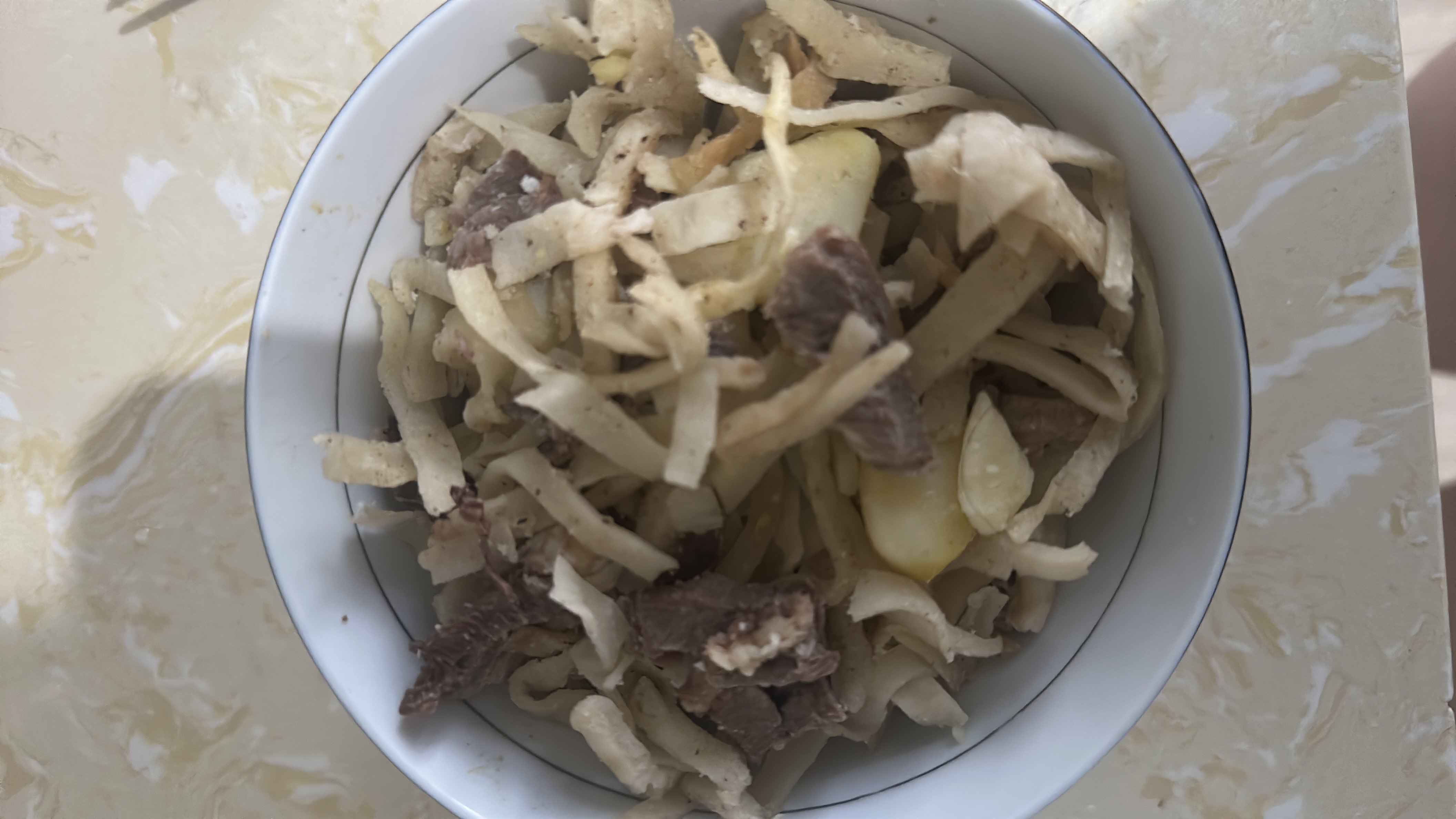A bowl of noodles with beef and vegetables, providing a balanced mix of protein, carbs, and fats.