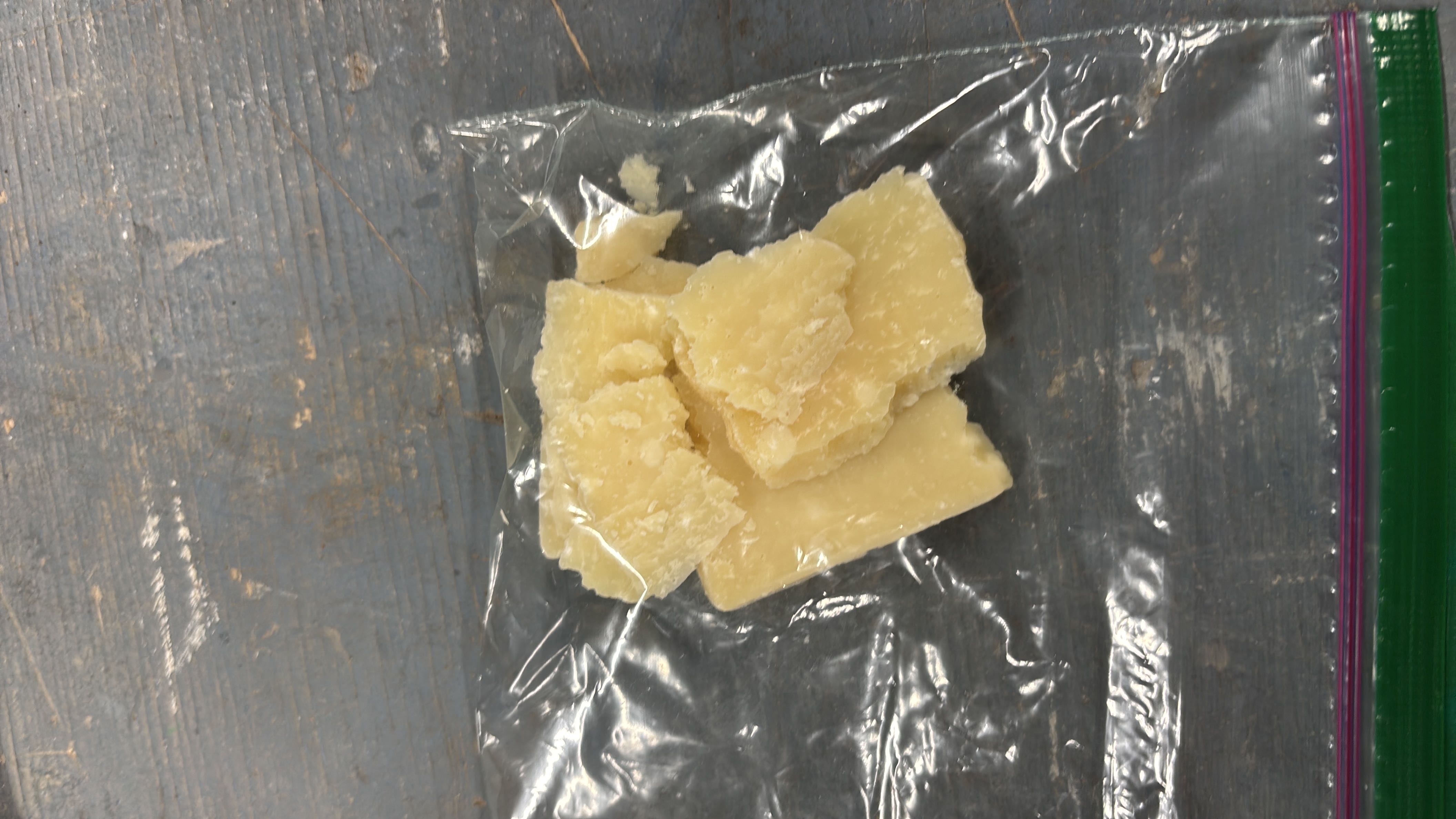 The image shows pieces of Parmesan cheese, a high-protein, low-carb dairy product with moderate fat content.