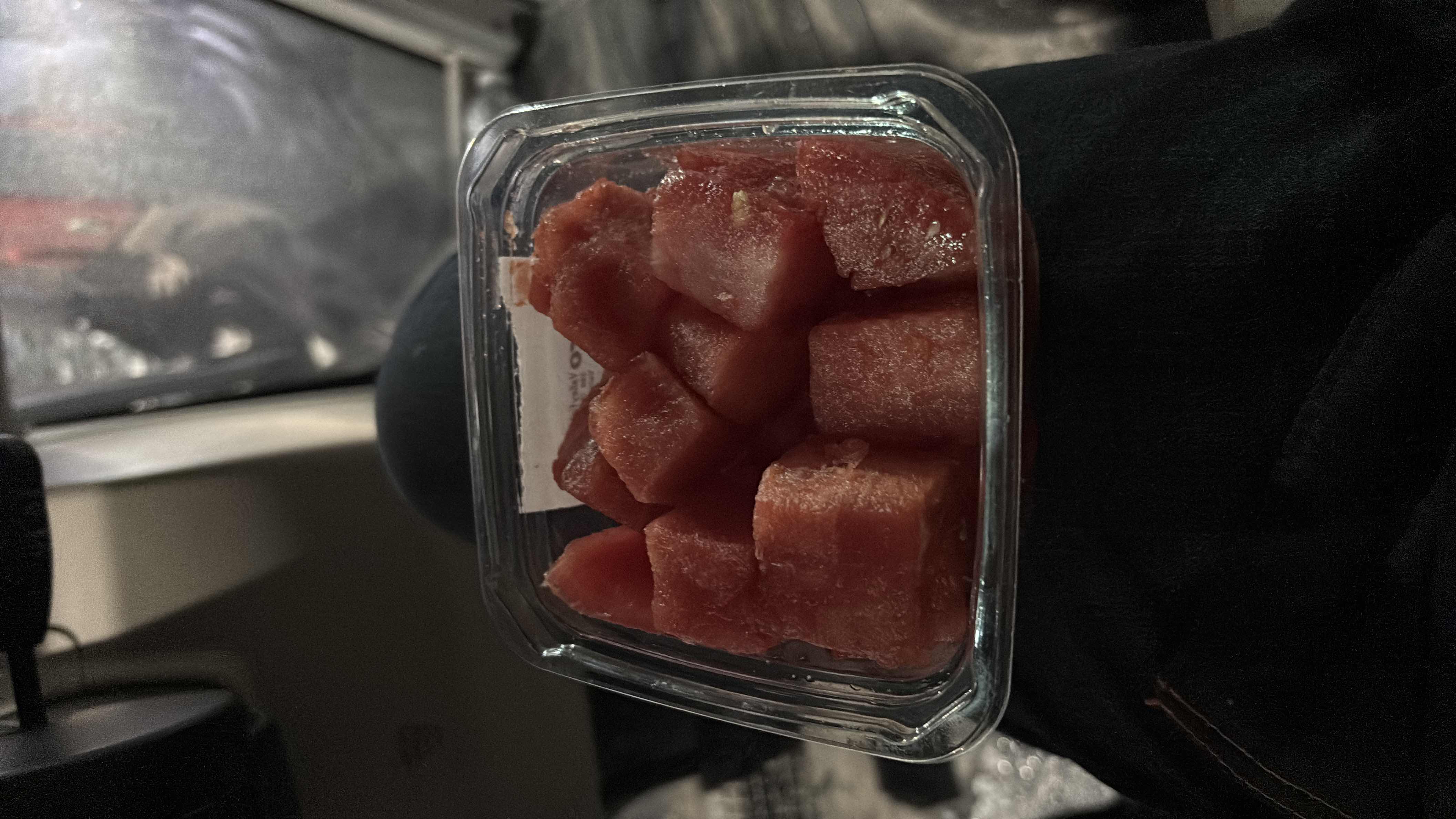 The image shows a container of diced watermelon, a low-calorie fruit rich in water content and carbohydrates, with minimal protein and fats.
