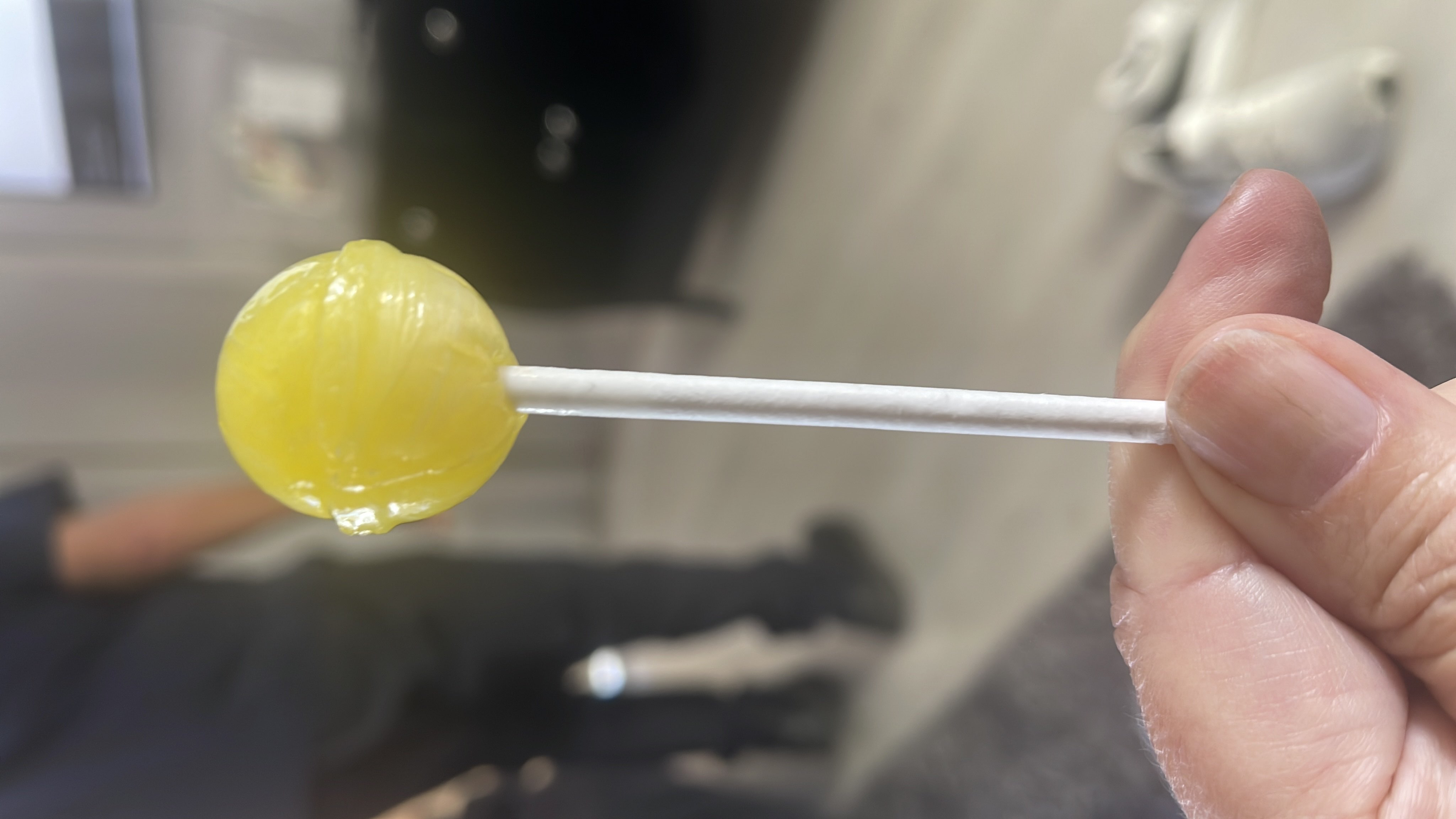 A yellow lollipop primarily made of sugar, providing quick energy with no protein or fats.