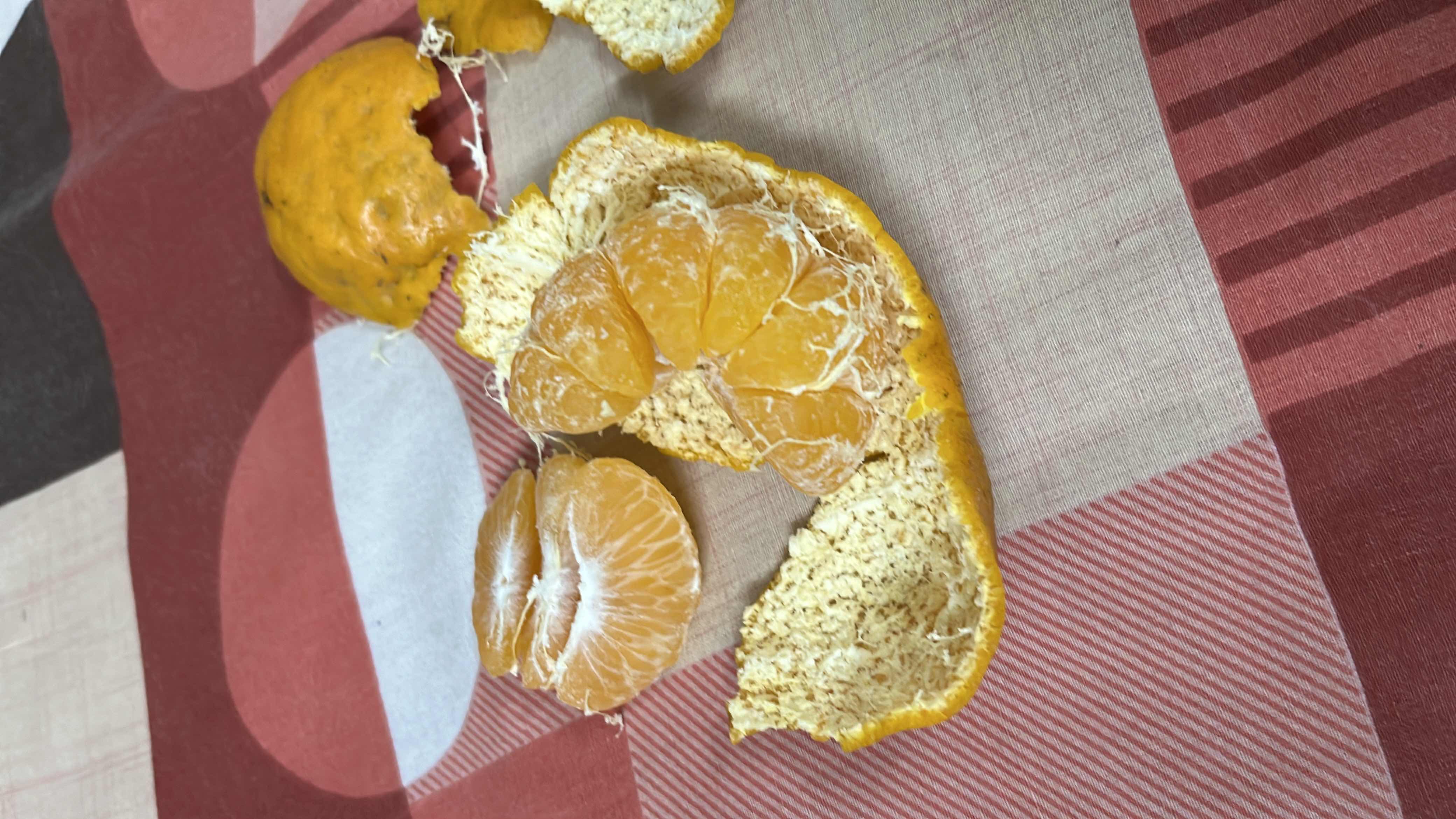The image shows a peeled mandarin orange, a low-calorie fruit rich in vitamin C and carbohydrates, making it a healthy snack option.