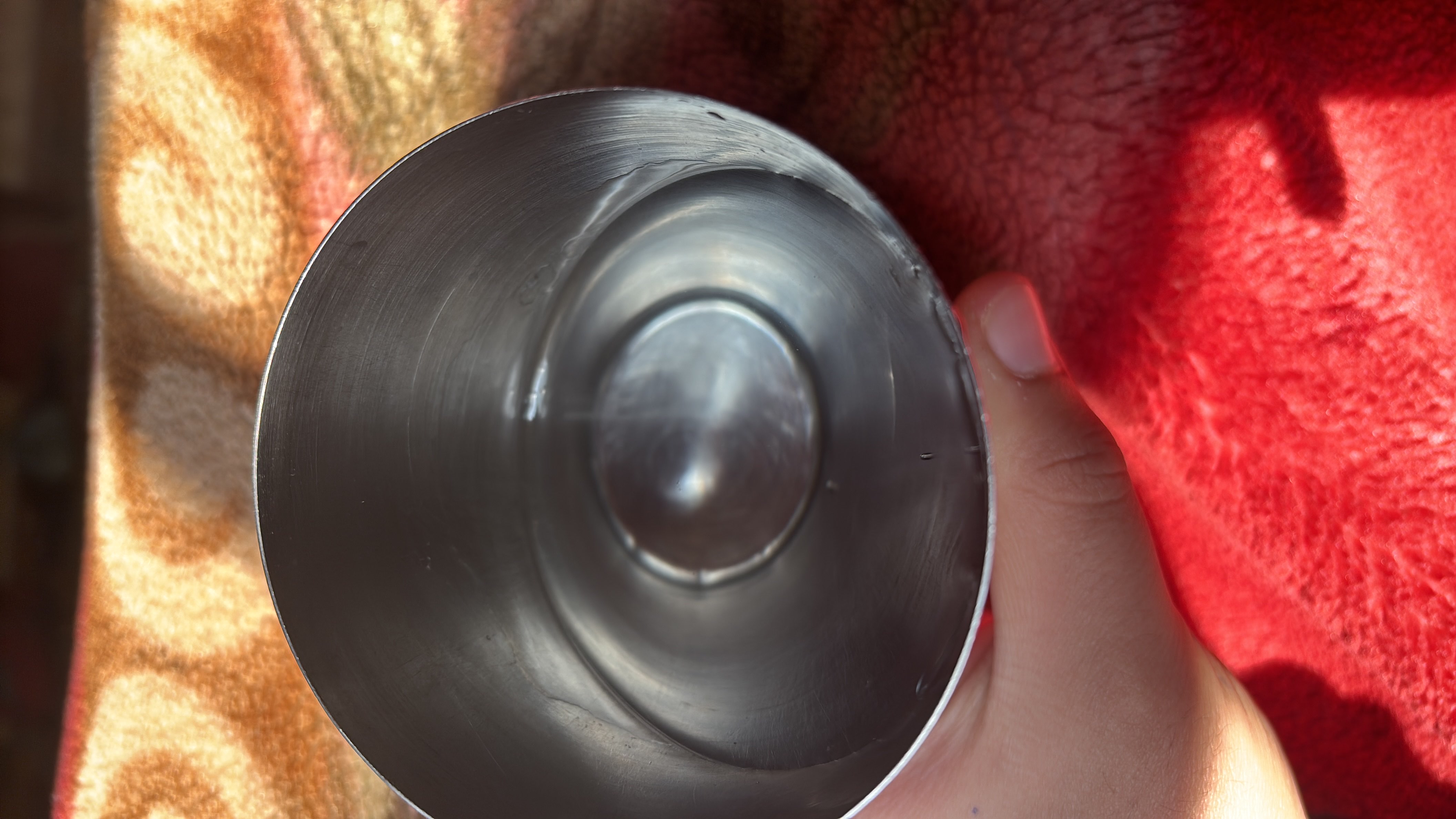 The image shows a stainless steel cup containing water, which has no calories, protein, carbs, or fats.
