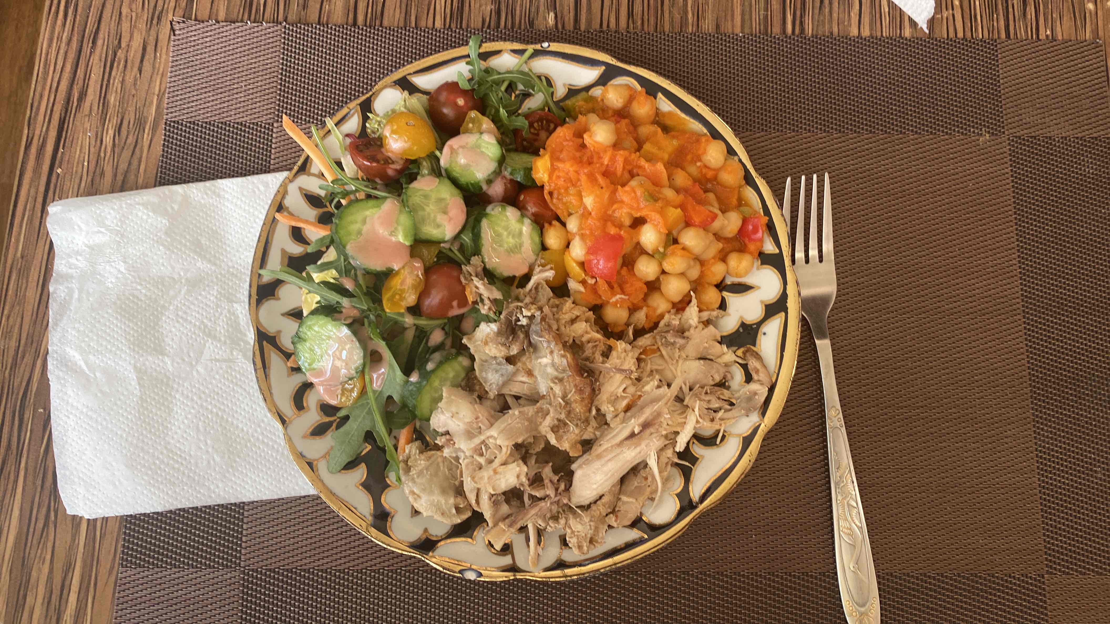 A balanced meal consisting of shredded chicken, chickpeas in a tomato-based sauce, fresh salad with dressing, and cooked vegetables.