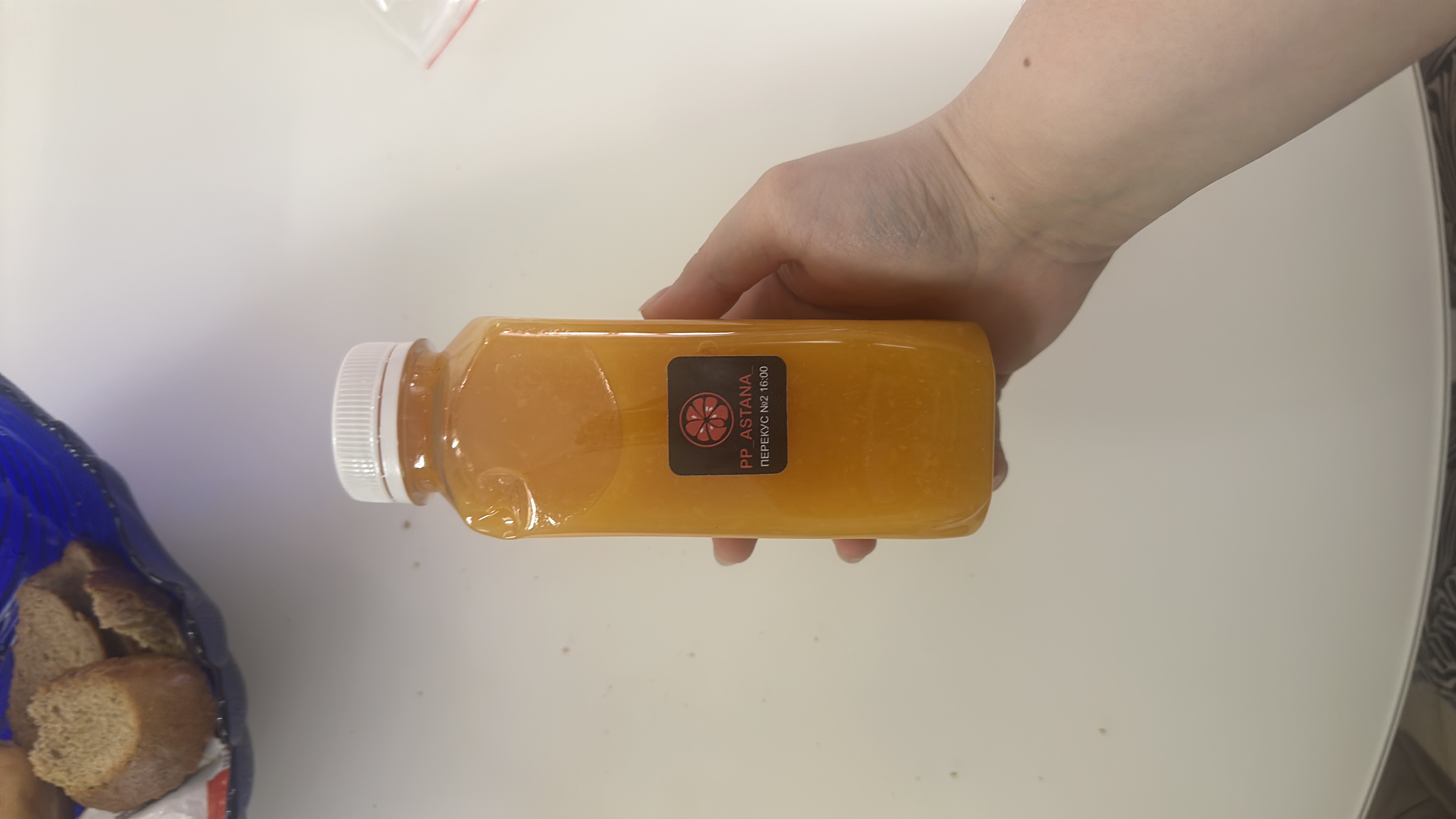A bottle of orange juice labeled 'PP Astana' with a focus on healthy nutrition.