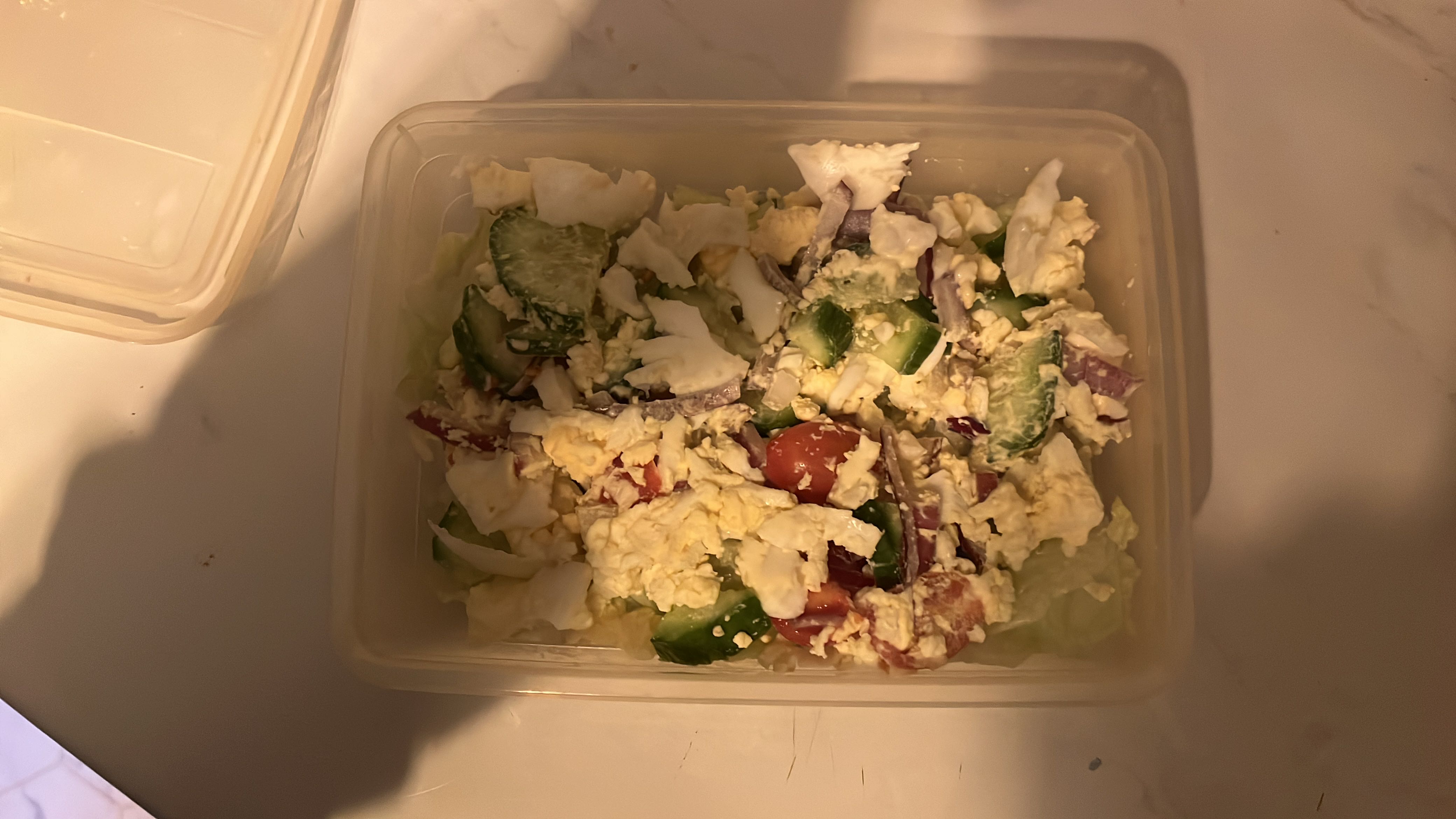 A fresh salad containing cucumber, tomato, feta cheese, lettuce, and onion, providing a balanced mix of protein, carbs, and fats.