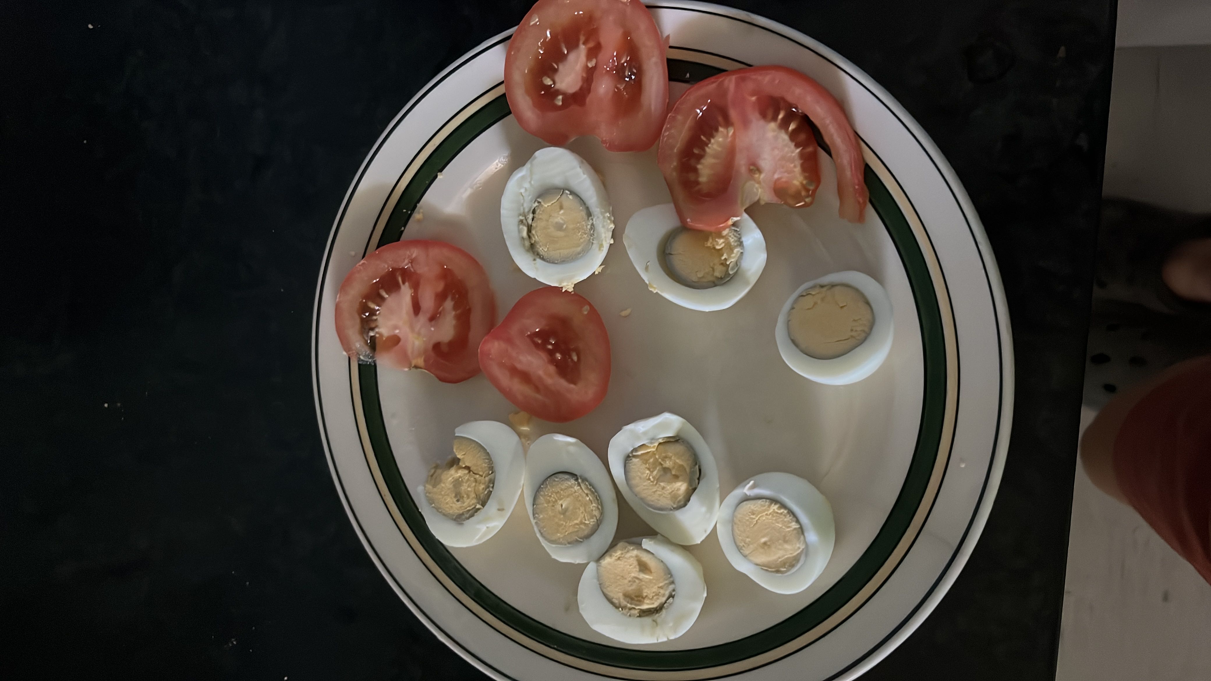 A plate containing boiled eggs and sliced tomatoes, providing a balanced mix of protein, fats, and minimal carbs.