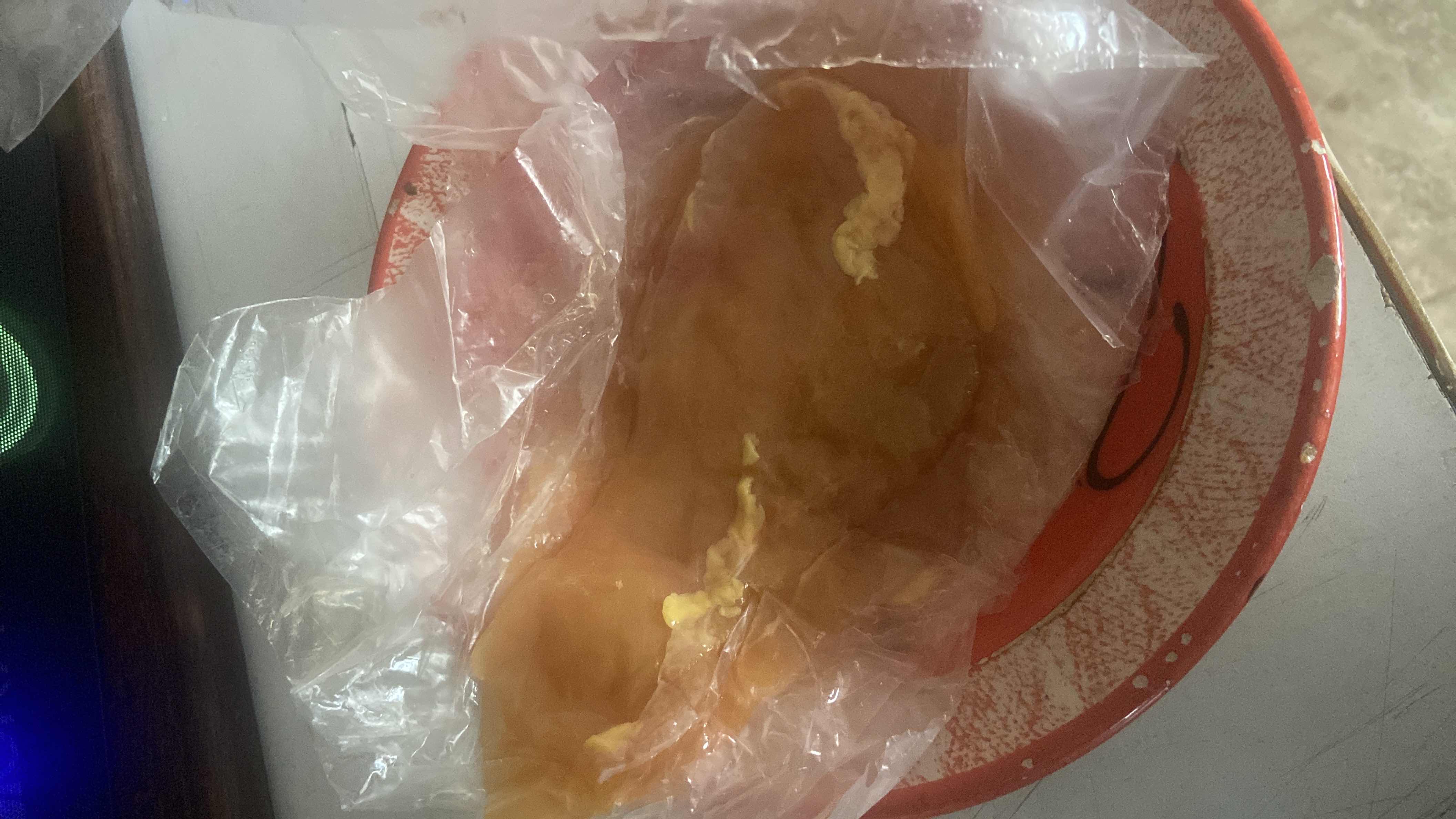 The image shows a raw chicken breast in a plastic wrap, which is a high-protein, low-carb food item.