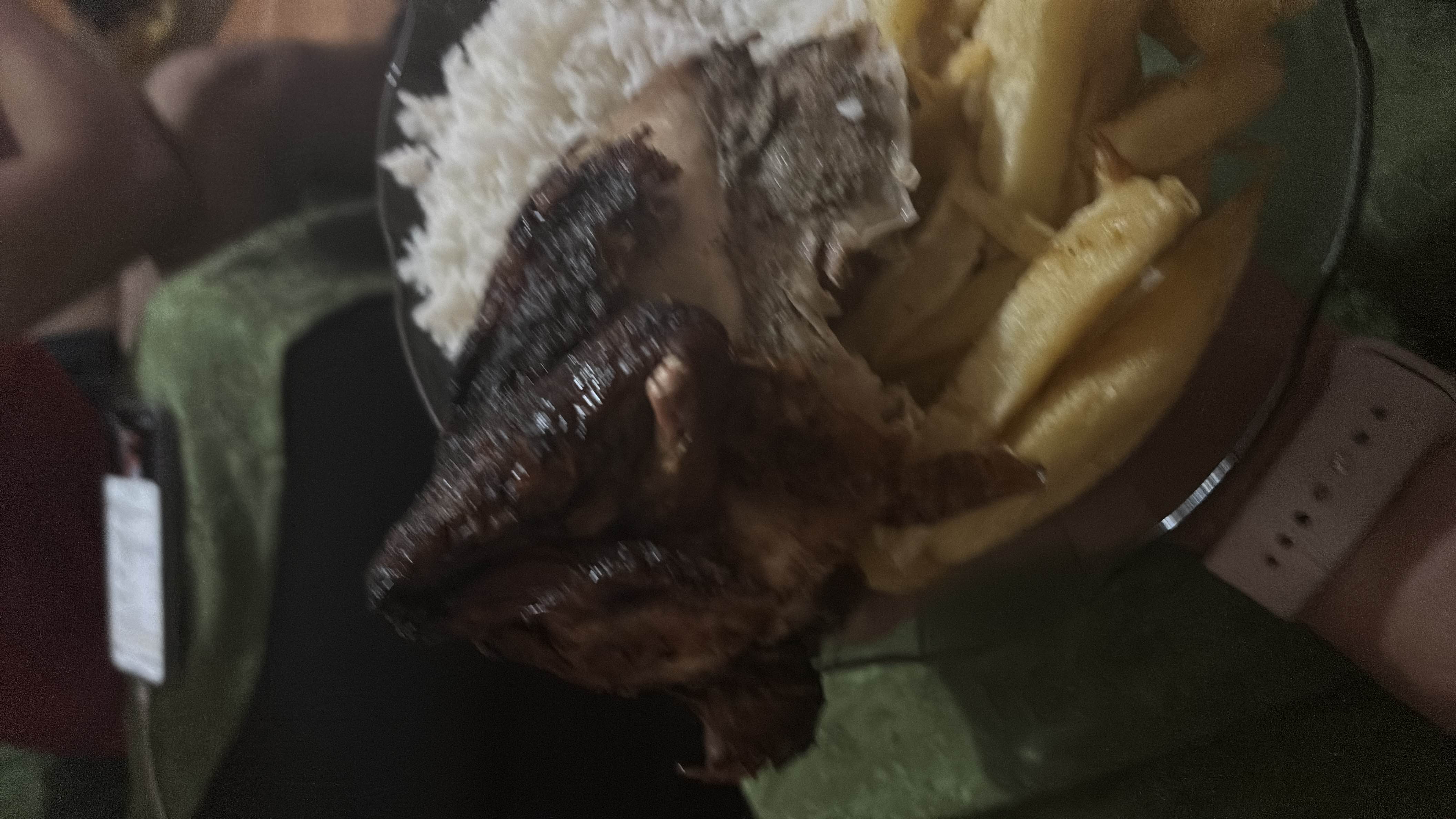 A plate containing grilled chicken, white rice, and fried potatoes, providing a balanced mix of protein, carbs, and fats.